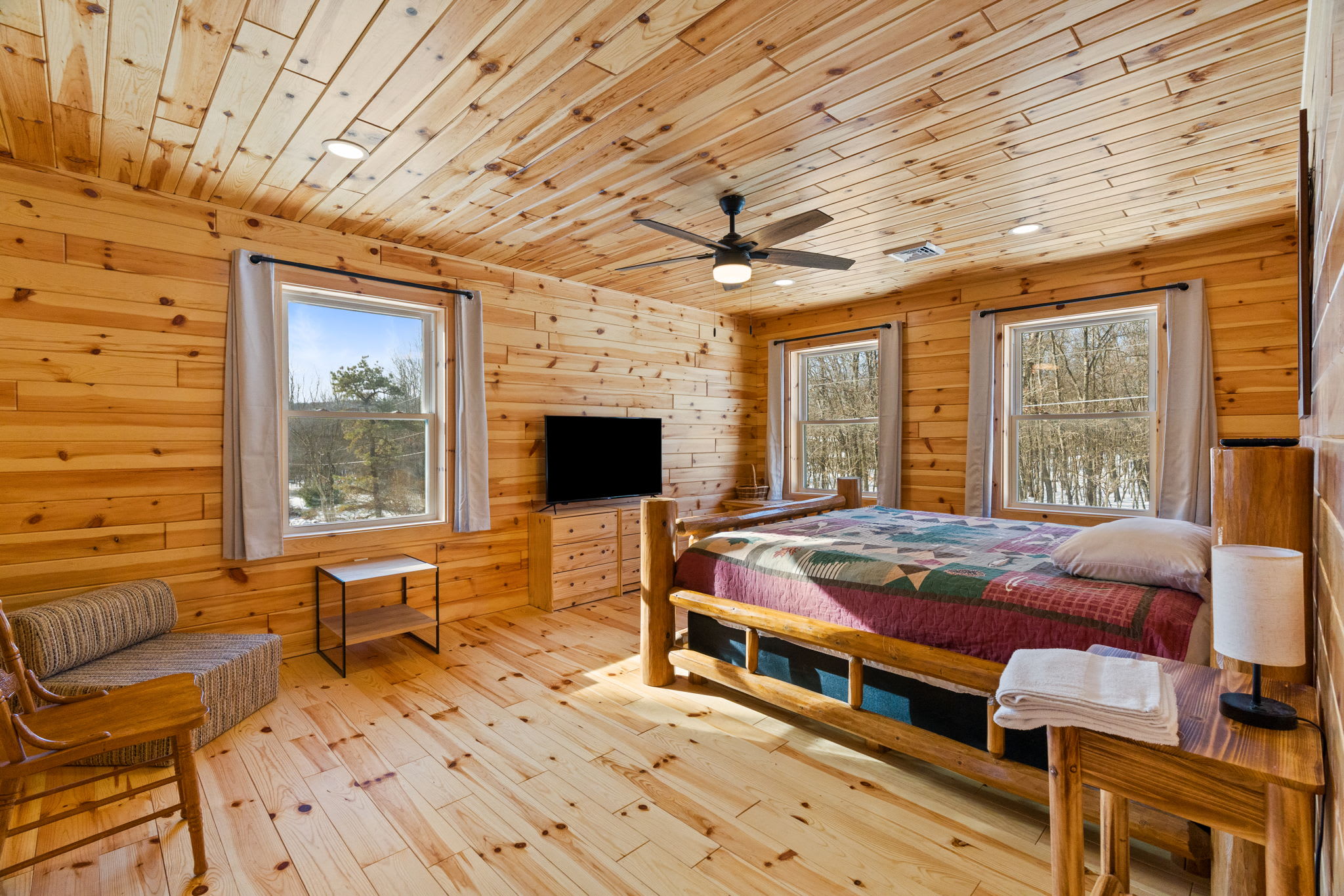 Snuggle up in the log-walled bedroom with a handmade quilt and peaceful wooded views