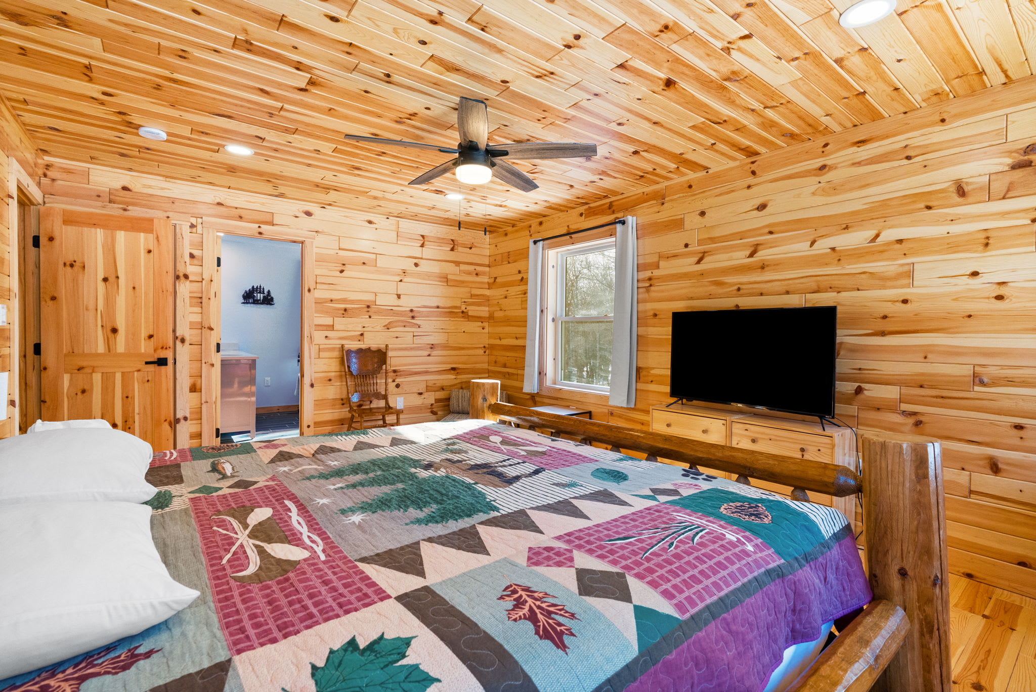 Bright bedding and natural wood beams make this bedroom a cheerful place to recharge