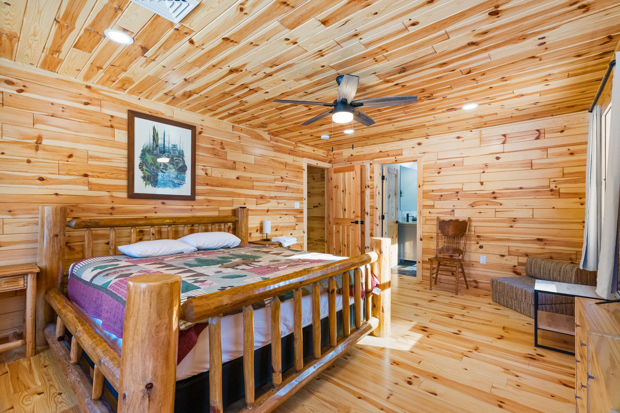 Colorful quilts and rustic log walls create a cozy mountain bedroom retreat