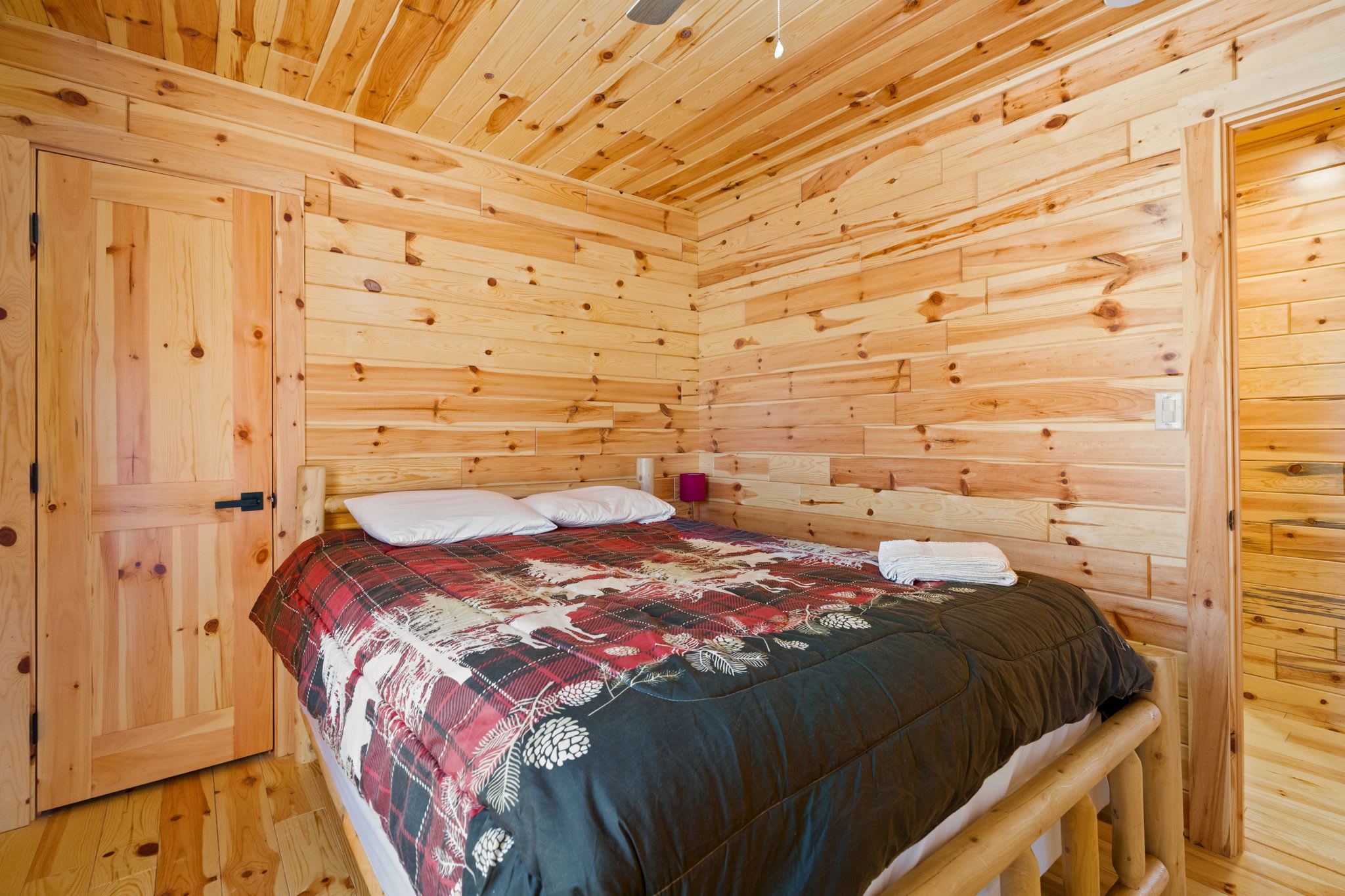 Plaid blankets and warm log walls set the scene for restful mountain nights