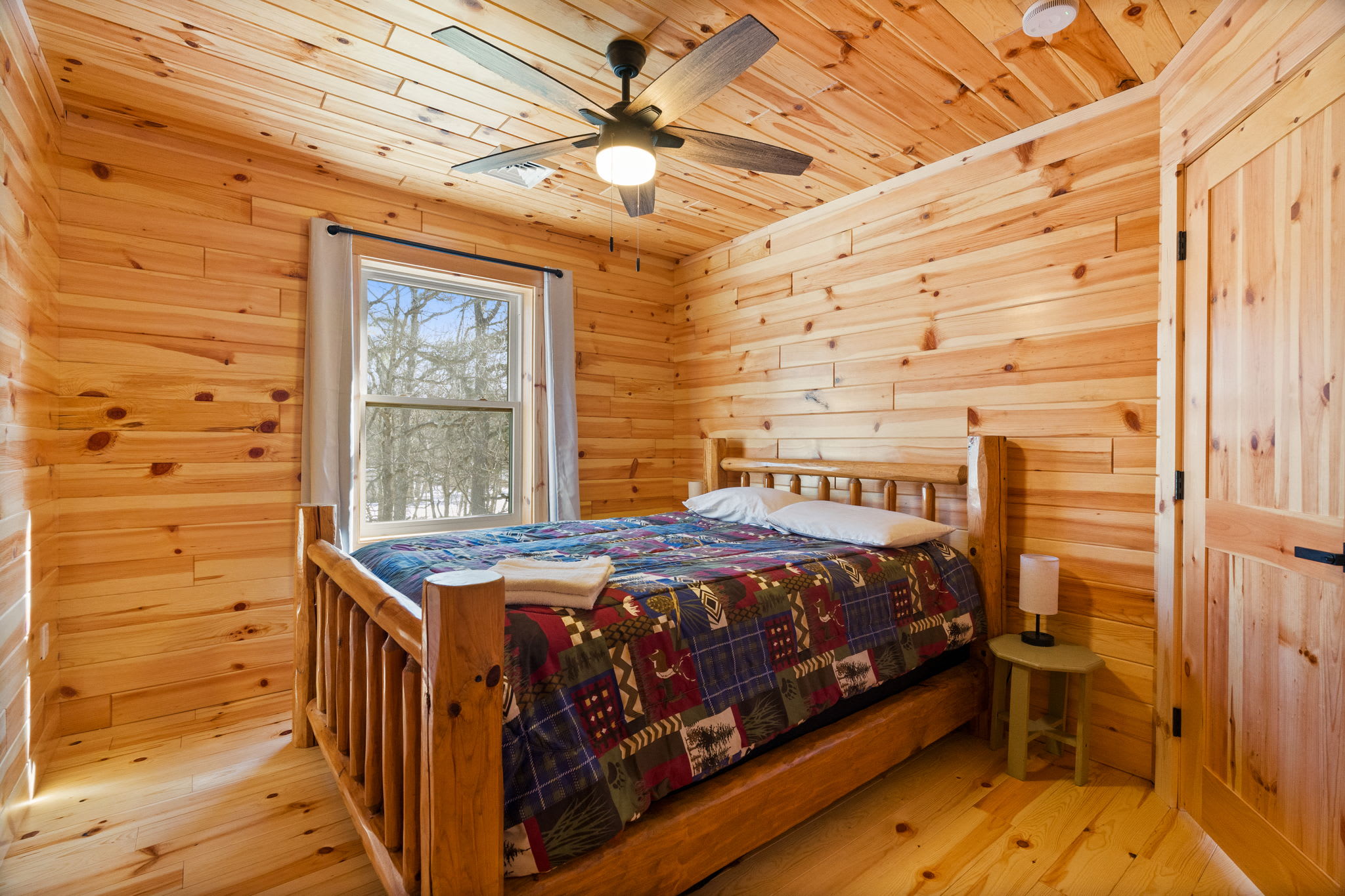 Wind down in this snug bedroom with a ceiling fan and classic cabin decor