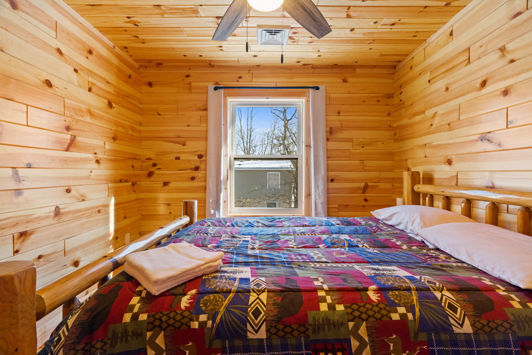 Fall asleep under a cozy patchwork spread with the forest just outside your window