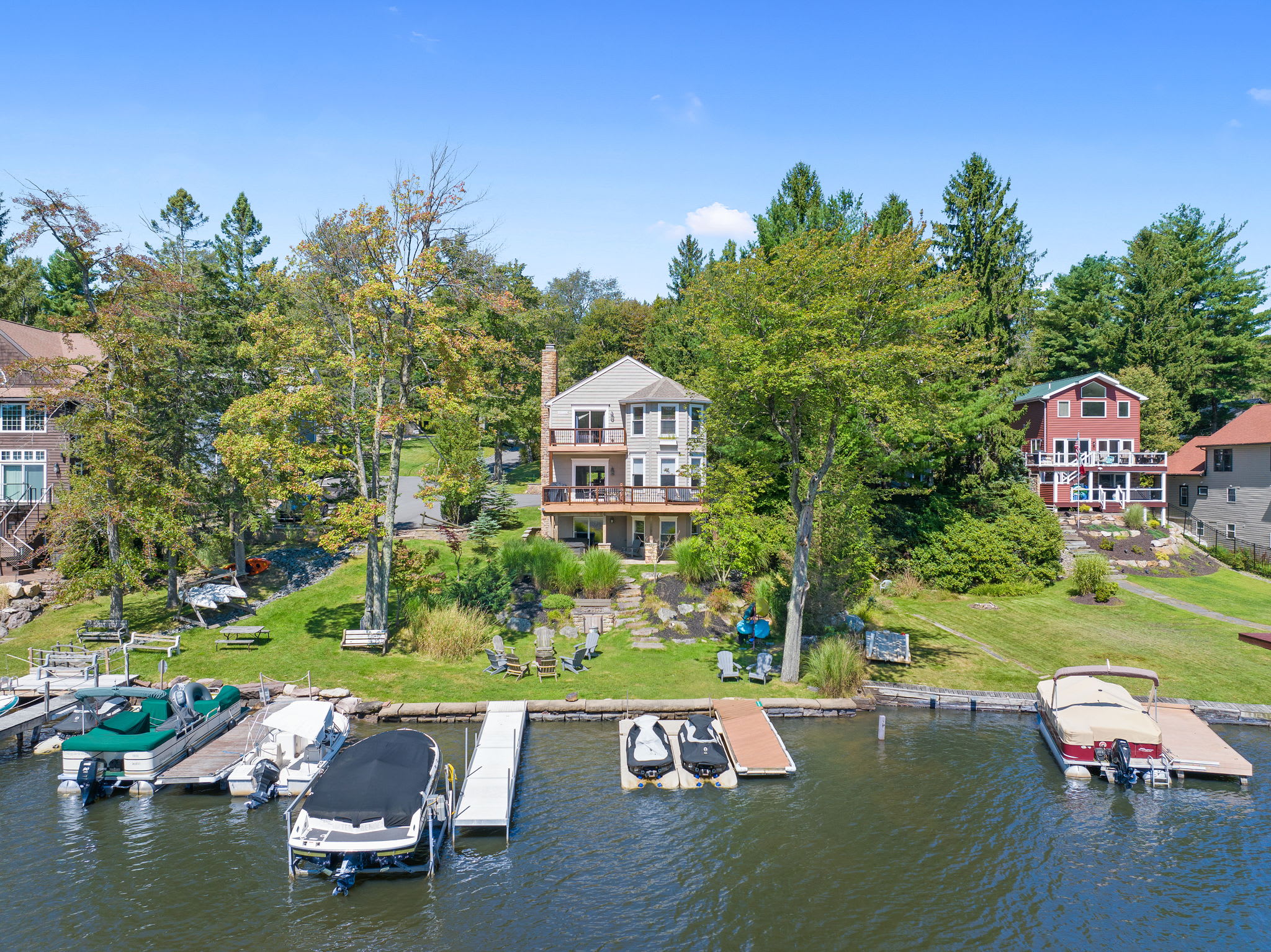 Aerial view of the property showing the dock, yard, and lake access