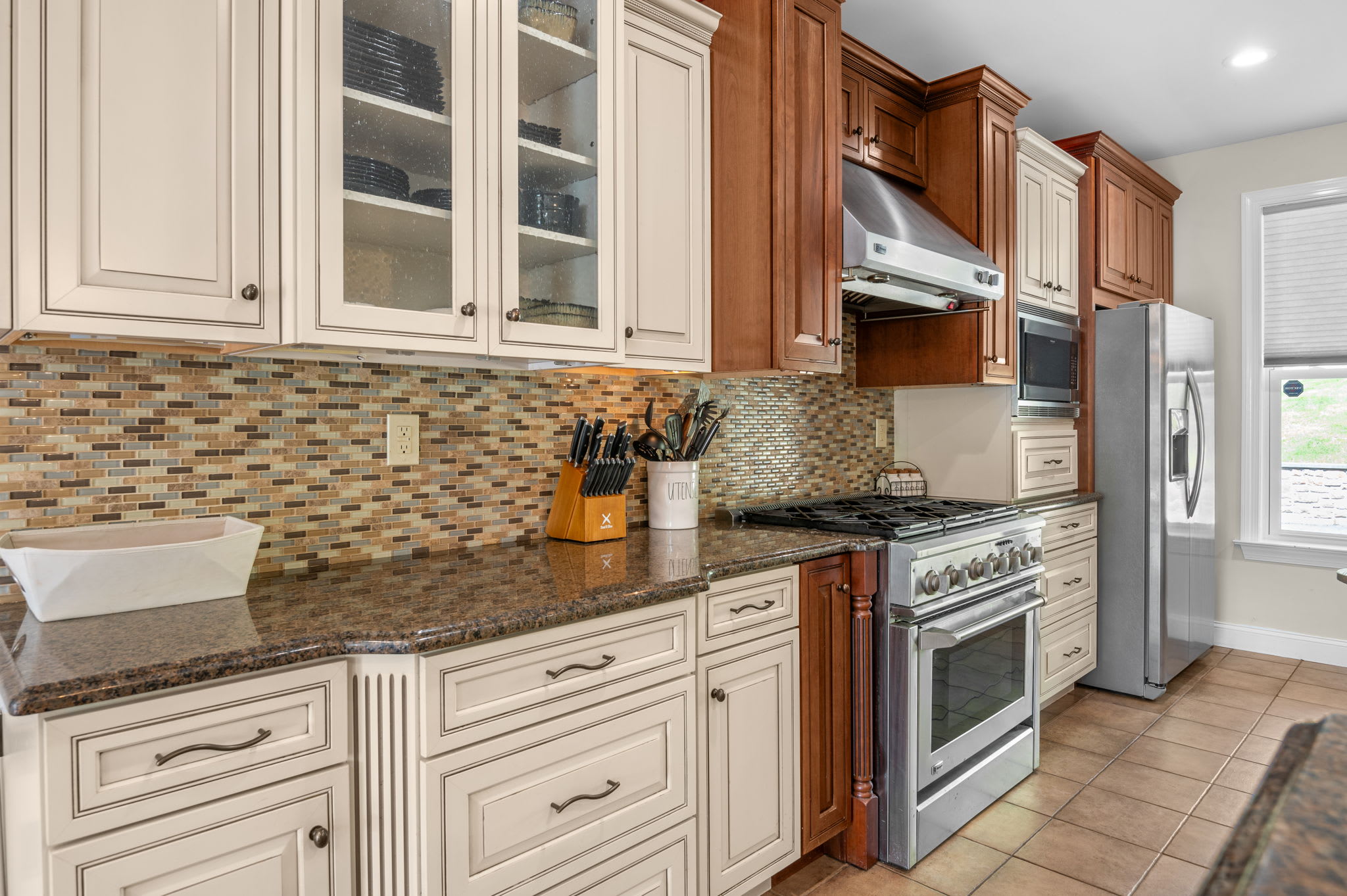 Glass-front cabinets and stainless appliances make this kitchen a dream to cook in