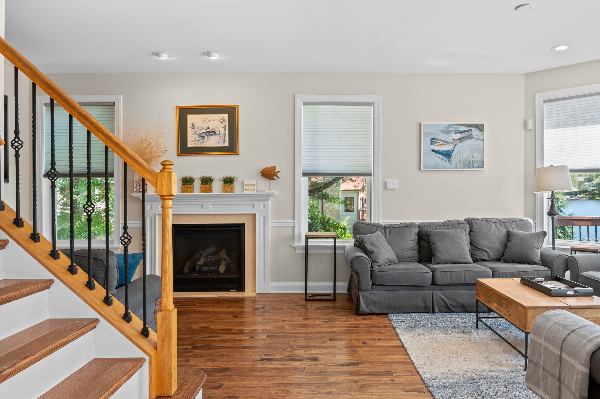 Cozy living room with a fireplace, comfy seating, and warm hardwood floors