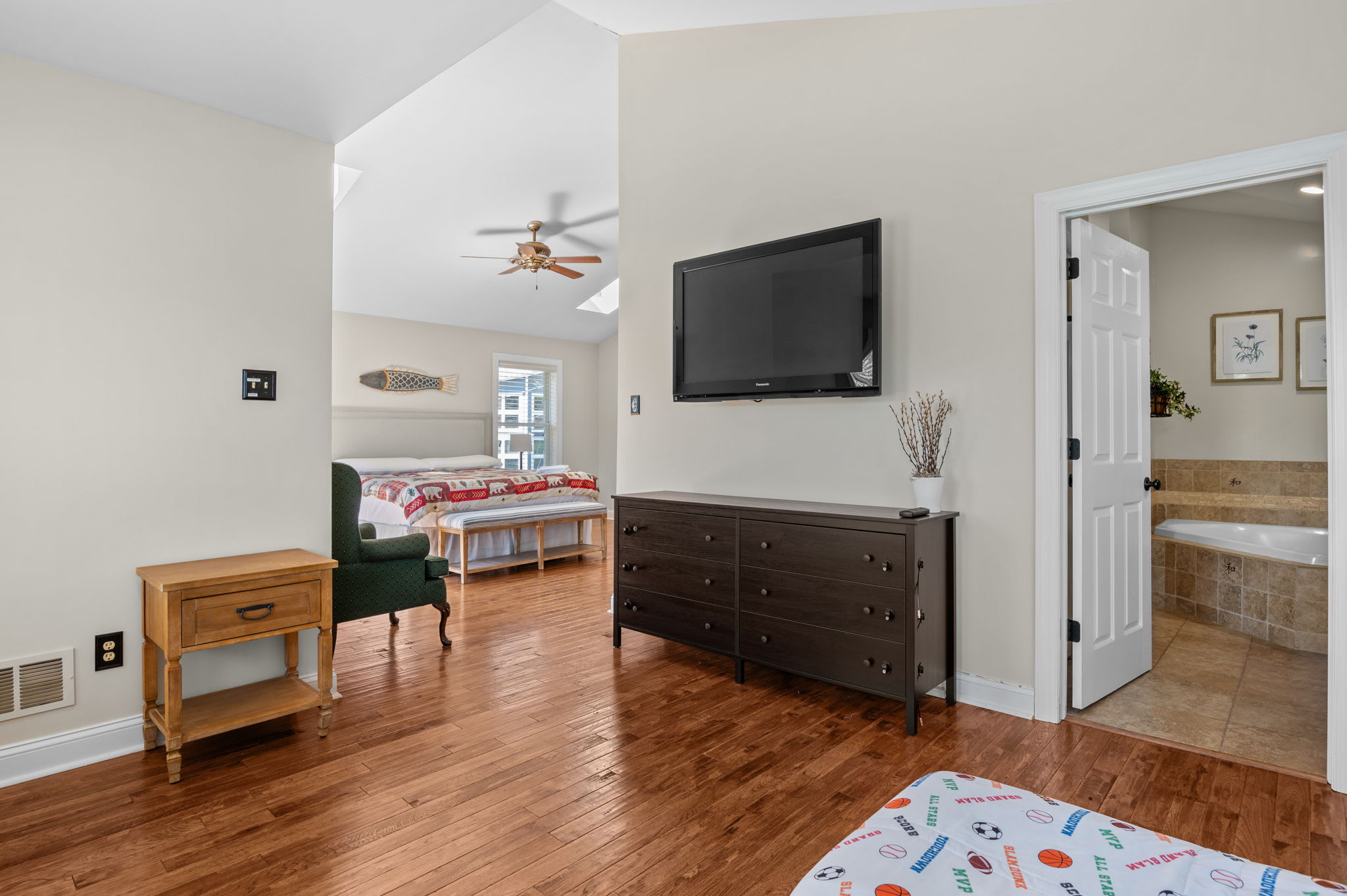 Master bedroom with a wall-mounted TV, closet, and ensuite bathroom access