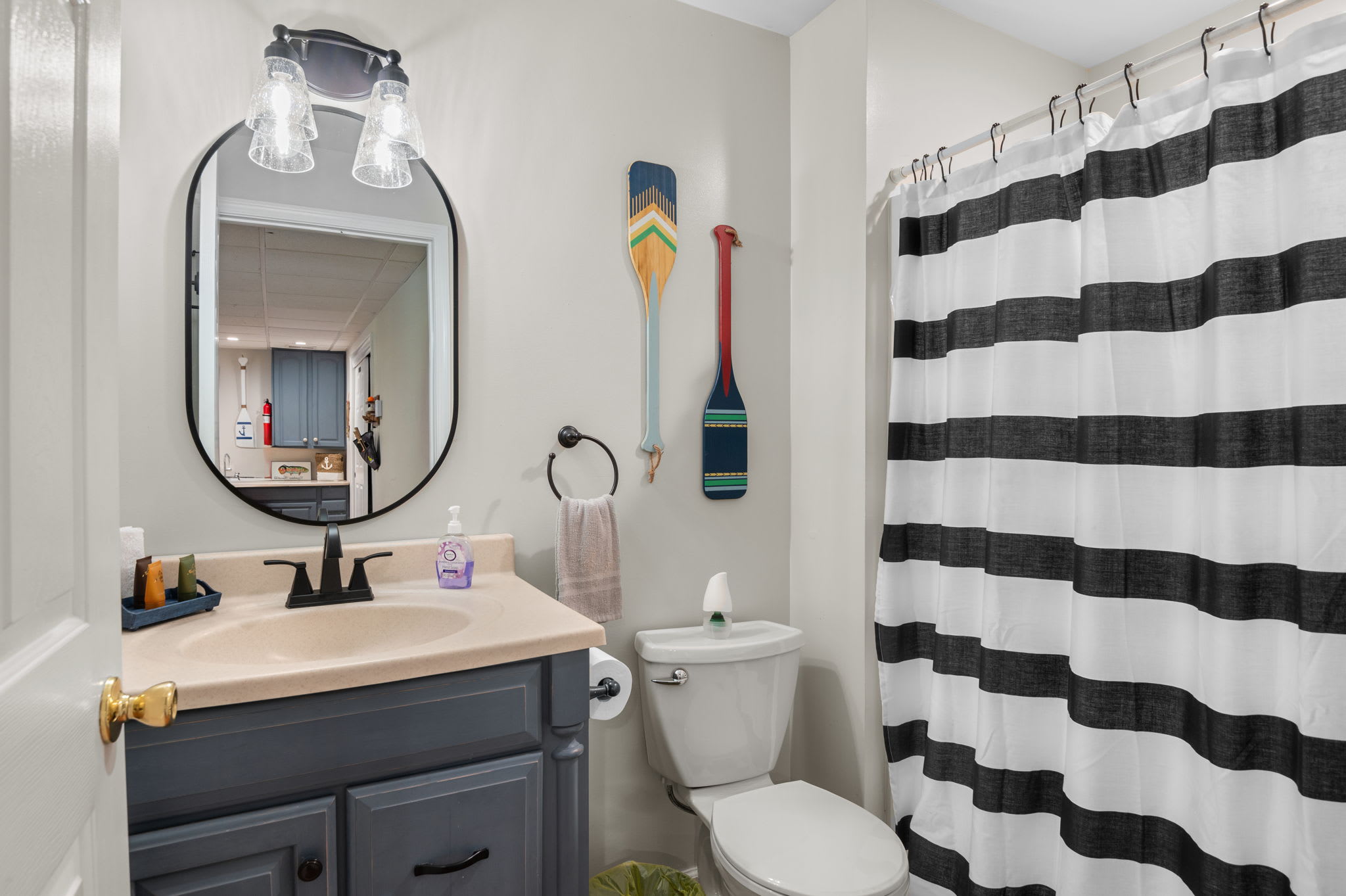 Lower-level bathroom with a modern vanity, mirror, and walk-in shower