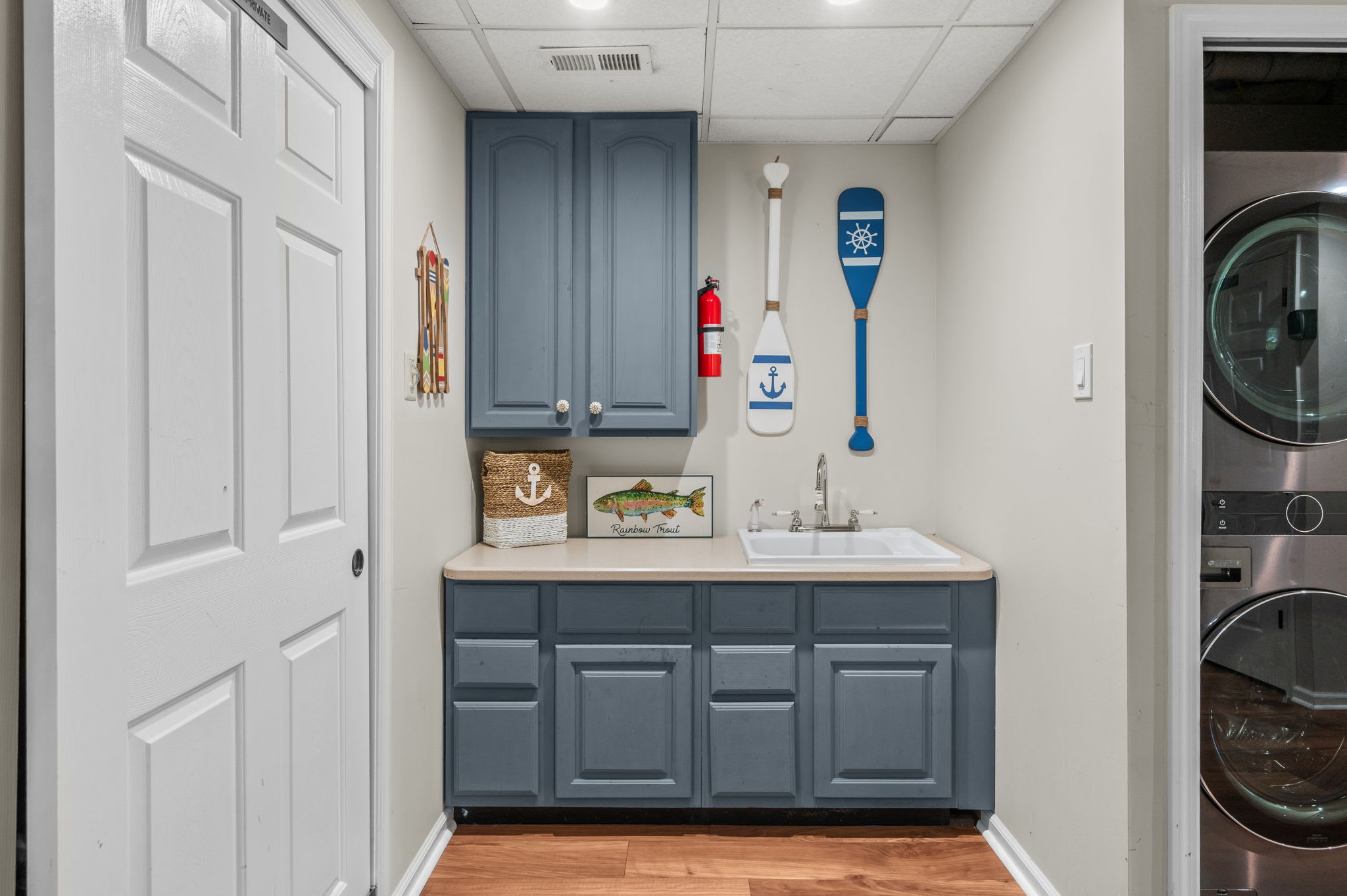 Lower-level wet bar with blue cabinetry and built-in storage for easy entertaining
