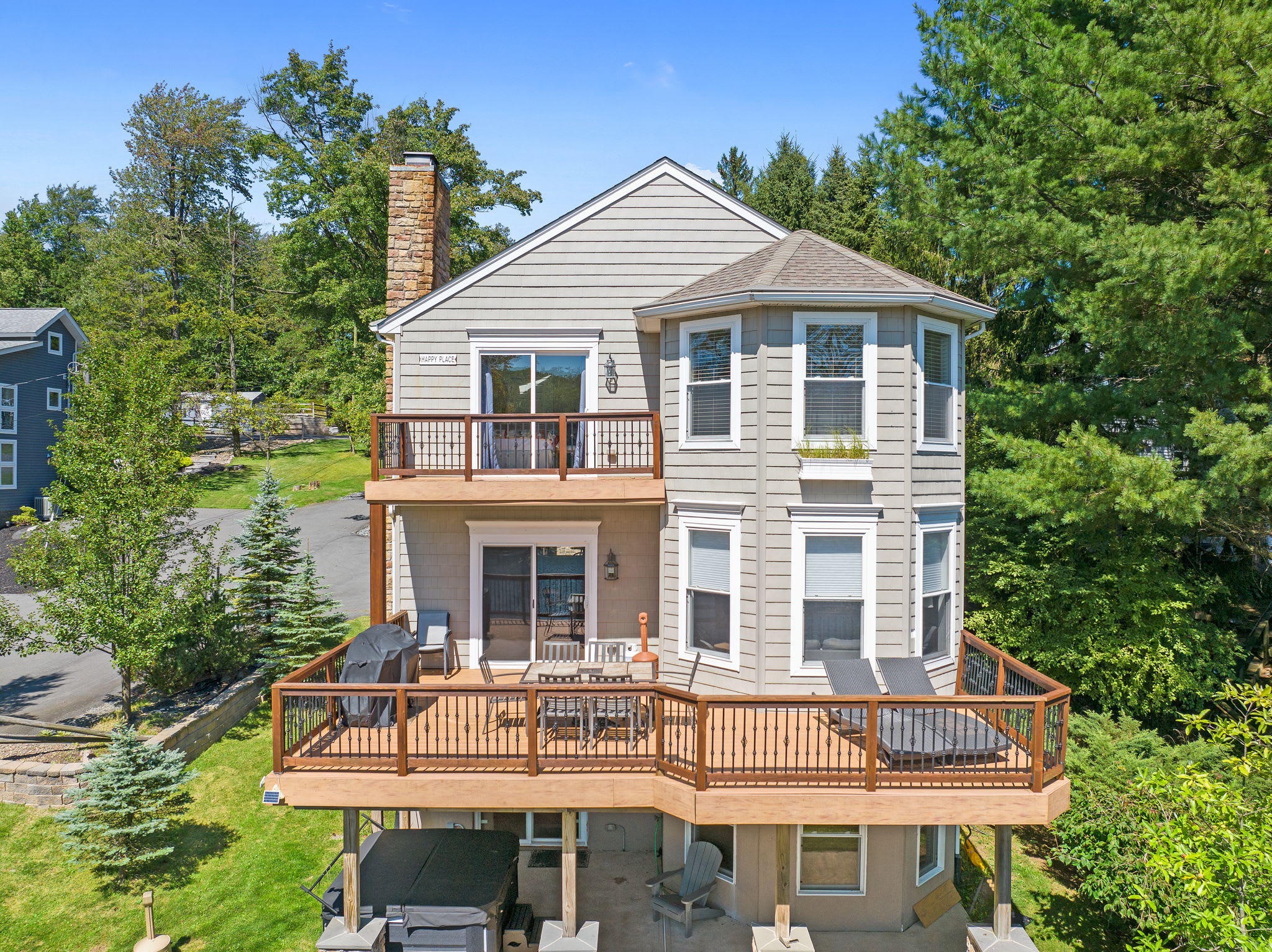 The lake house from the front with balconies, covered porch, and wood siding