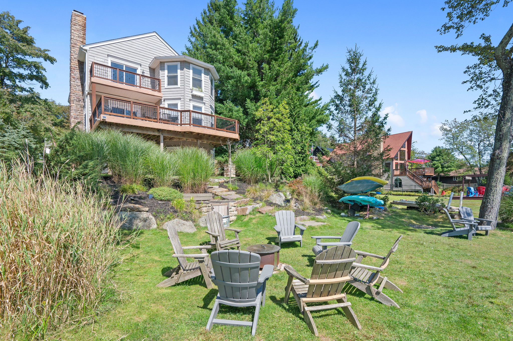 Spacious backyard with outdoor seating, a fire pit area, and green lawn