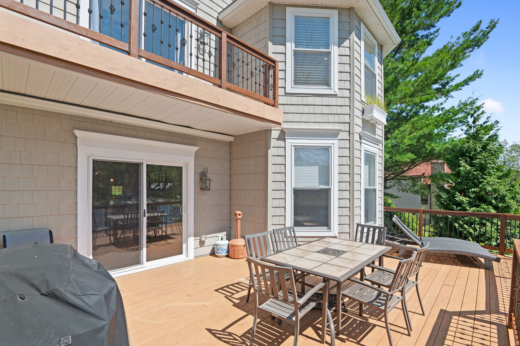 Dine al fresco on the covered patio with an outdoor dining set and grill nearby