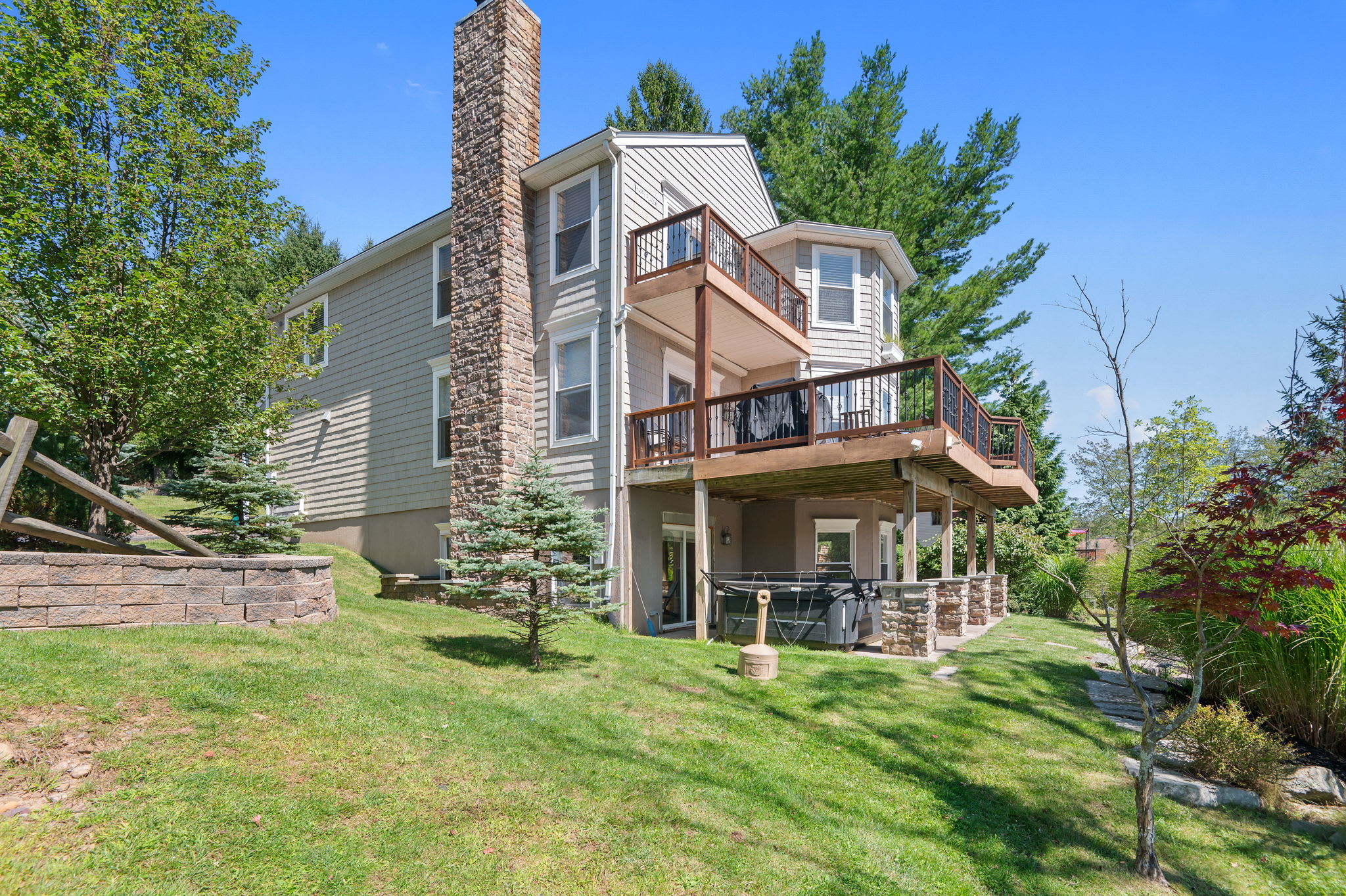 Back exterior showing the three-level home with decks overlooking the yard