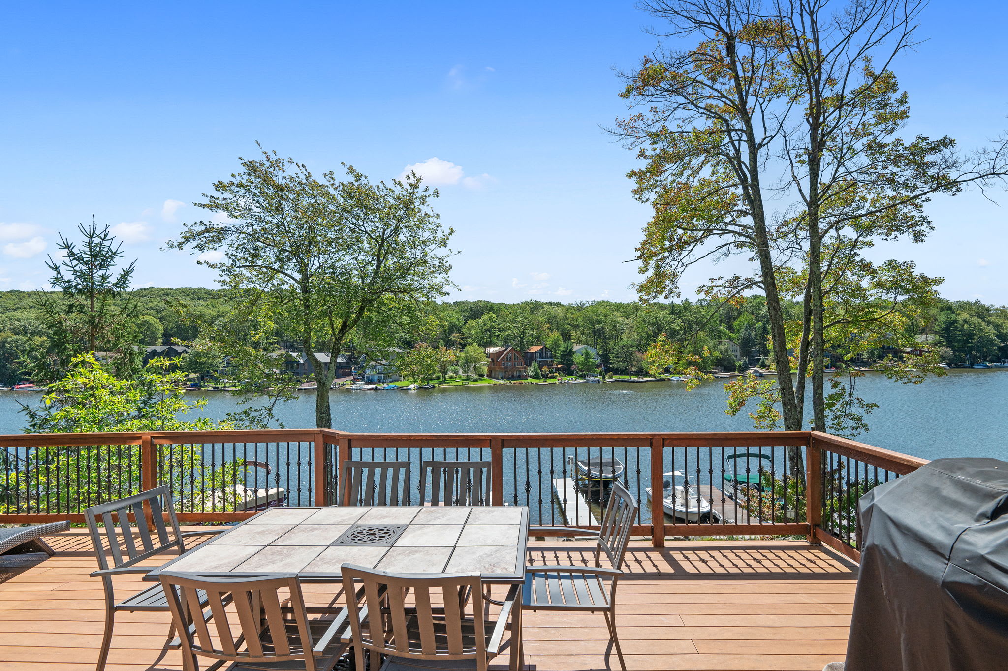 Enjoy meals on the deck with a dining table and panoramic lake views