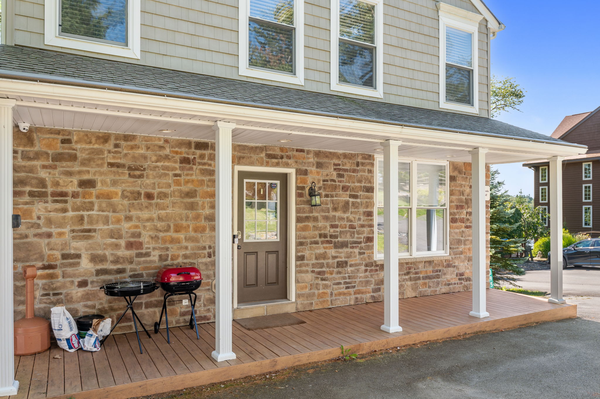 Covered front porch with columns and a grill ready for cookouts