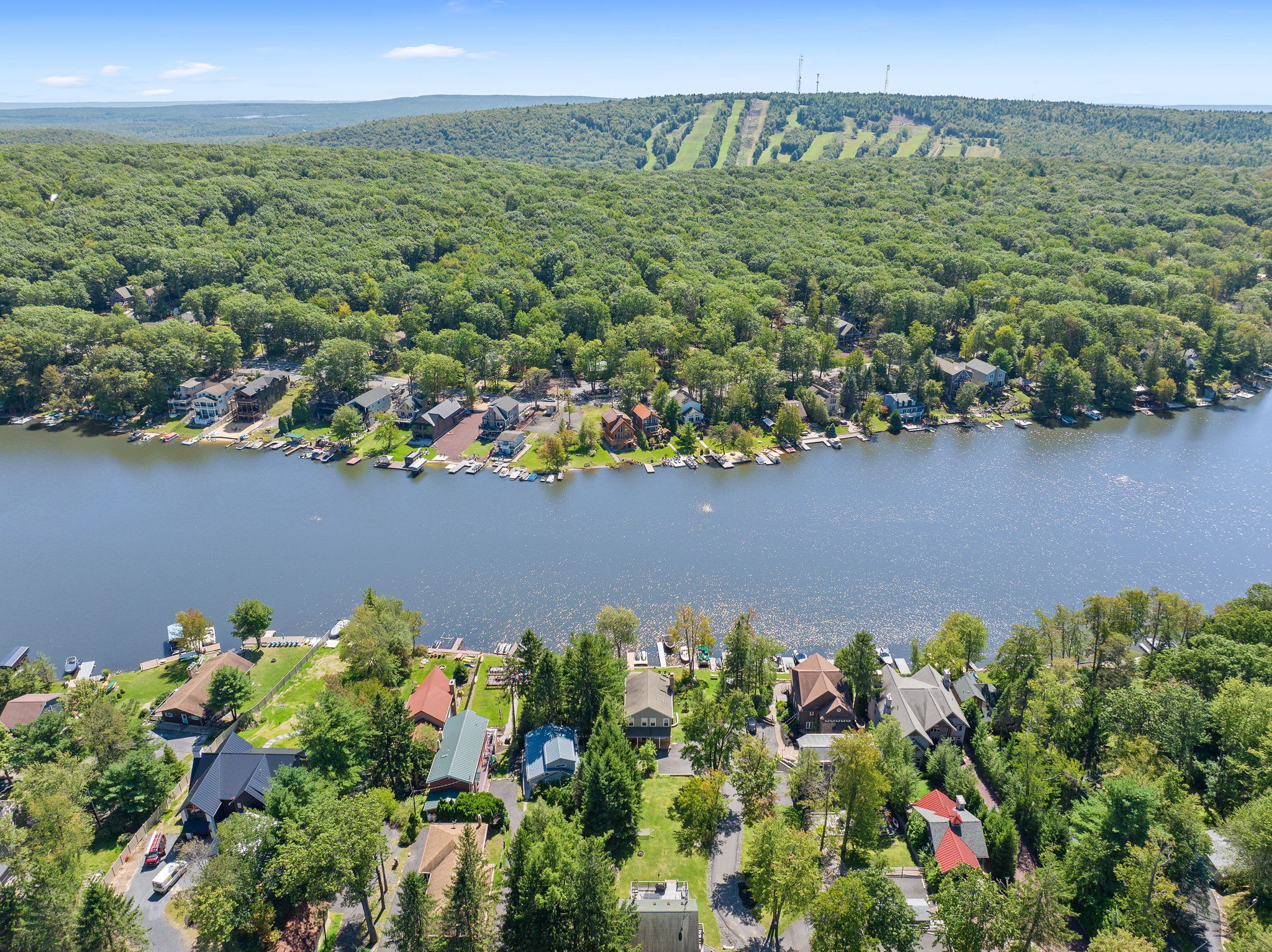 Sweeping aerial of Lake Harmony with homes nestled along the wooded shoreline