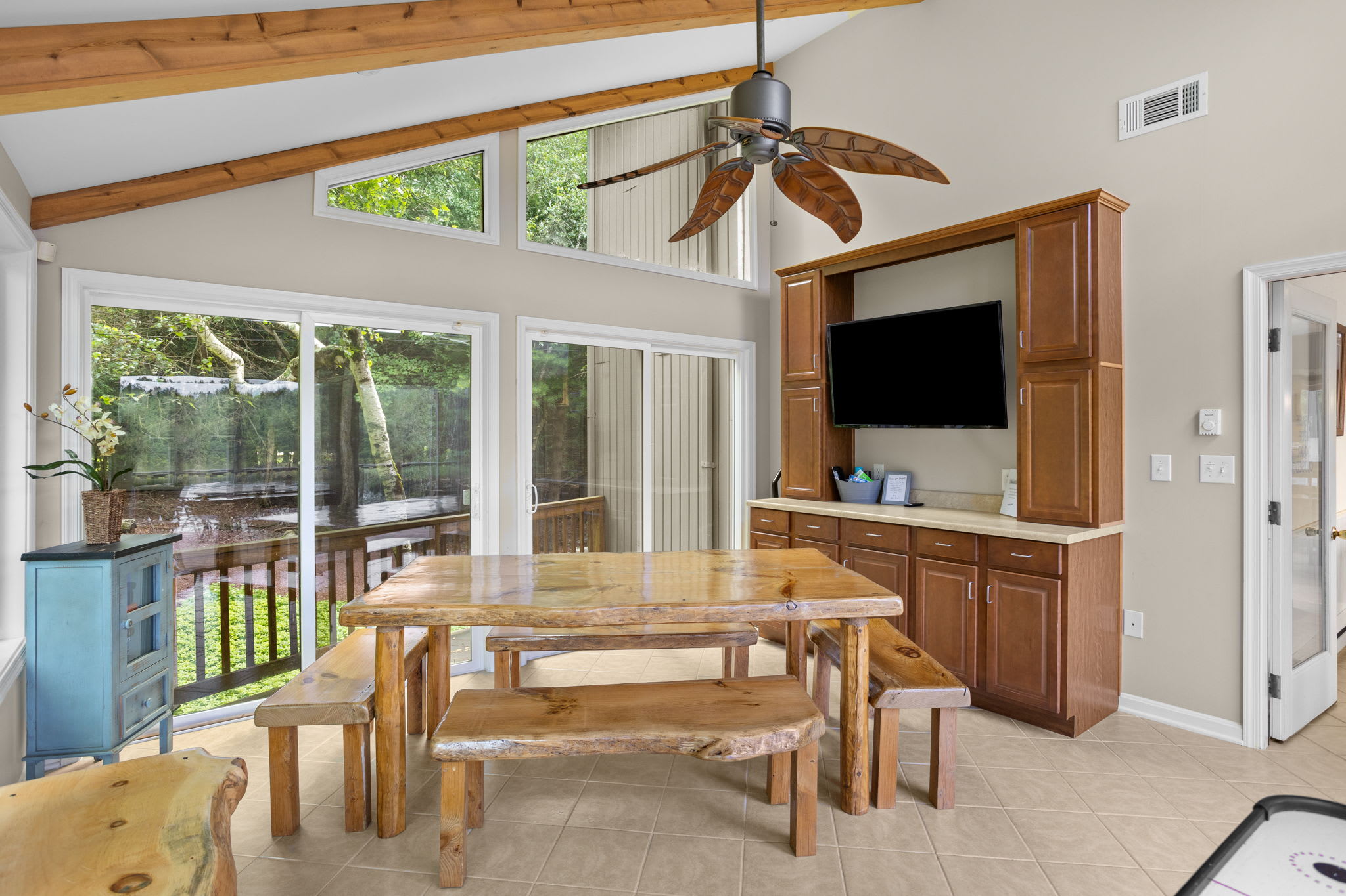 A cozy den with warm wood walls and a view of the deck