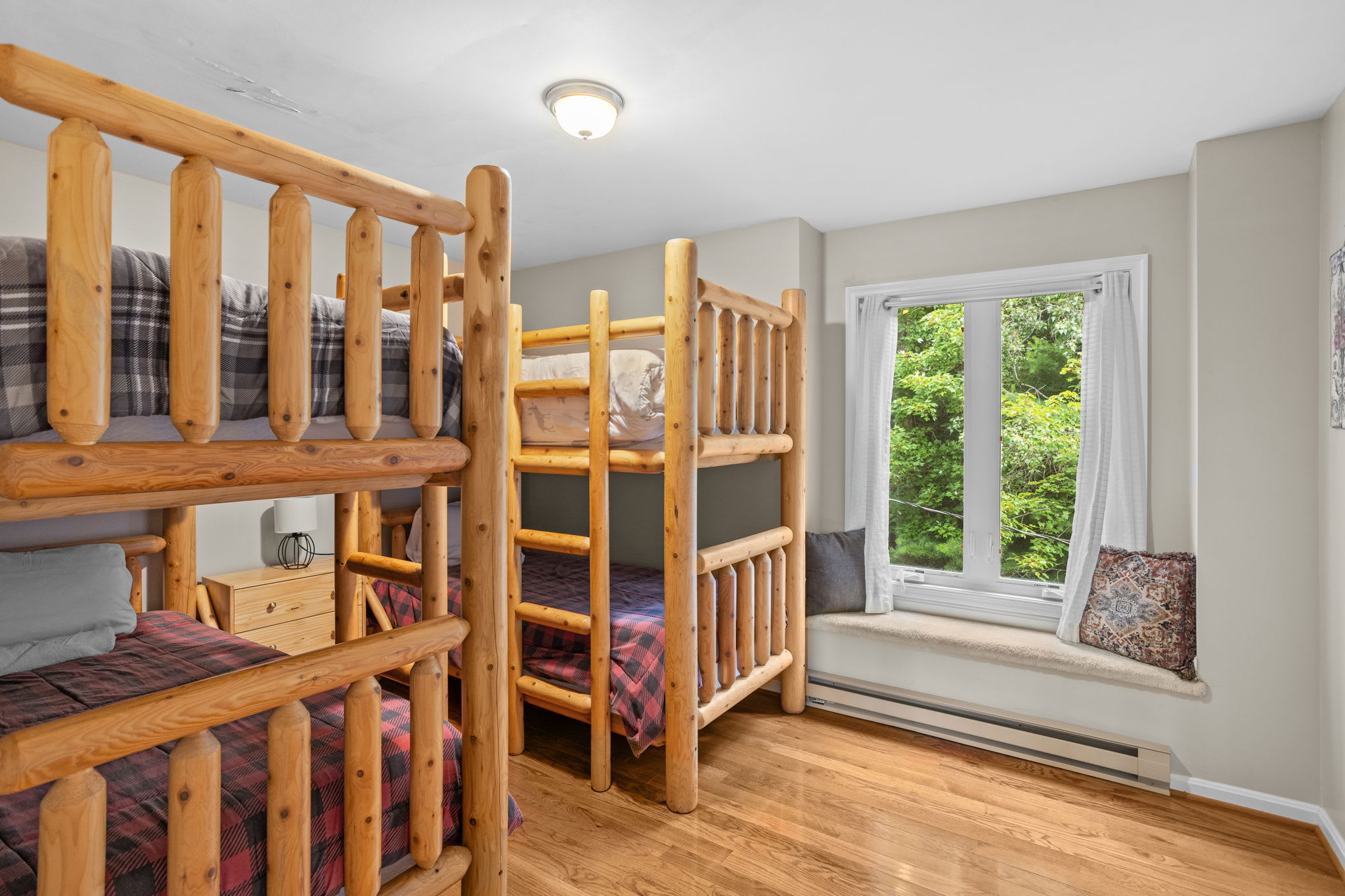 Log bunk beds with a window view of the trees outside