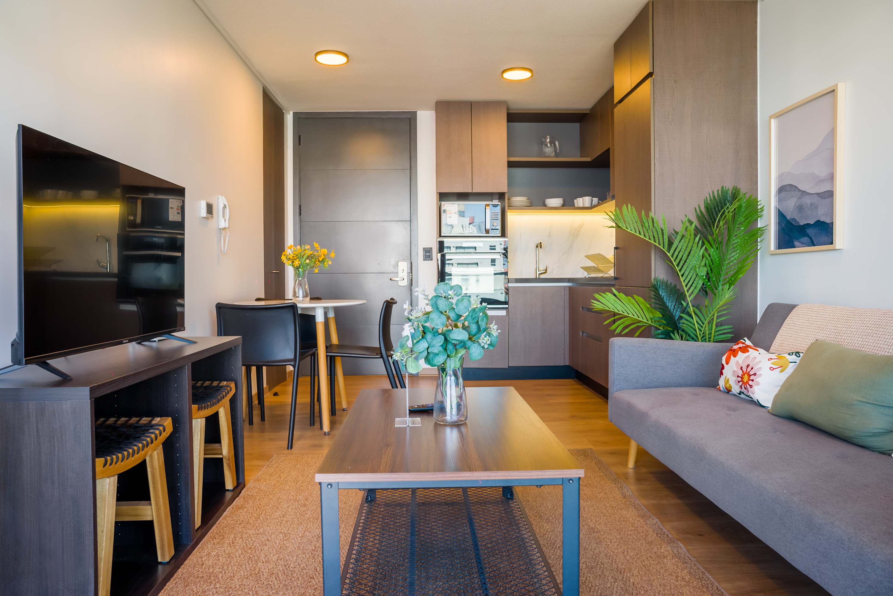 Cozy and modern living space with a sleek kitchen and comfortable seating, perfect for relaxation and dining.
