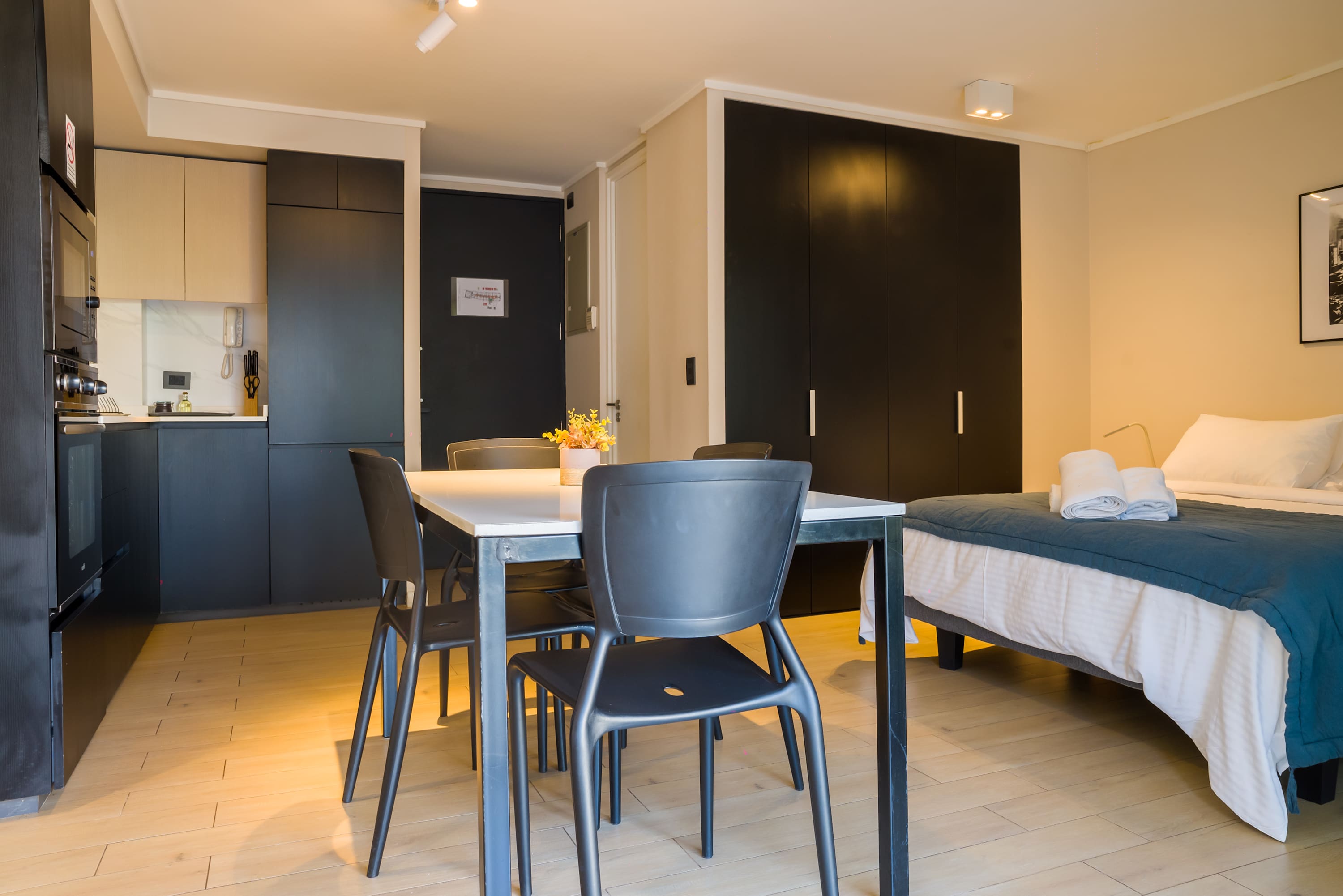 Modern studio with sleek kitchen and cozy dining area, perfect for city stays.