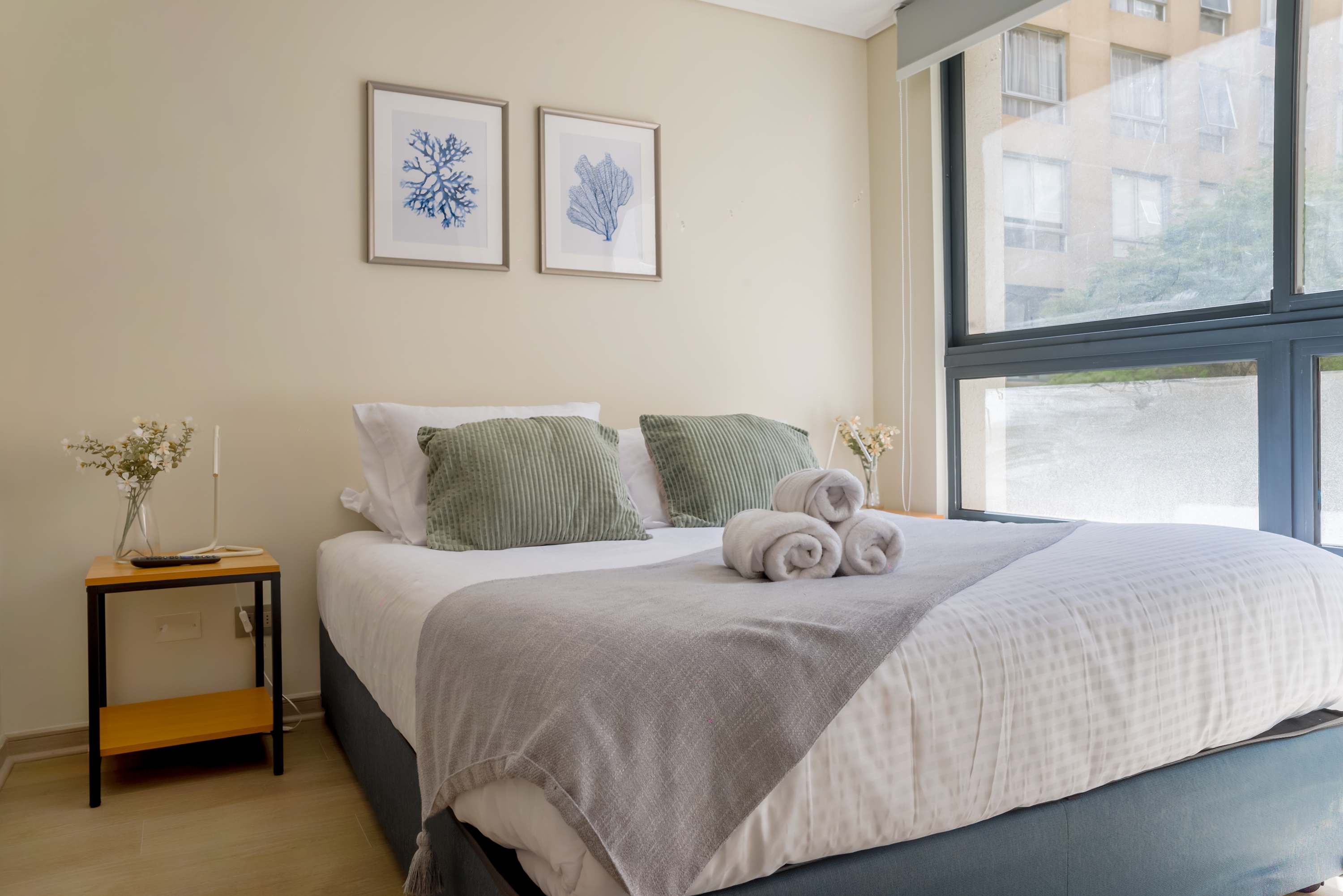 Cozy bedroom with large windows and stylish decor, perfect for a relaxing stay.