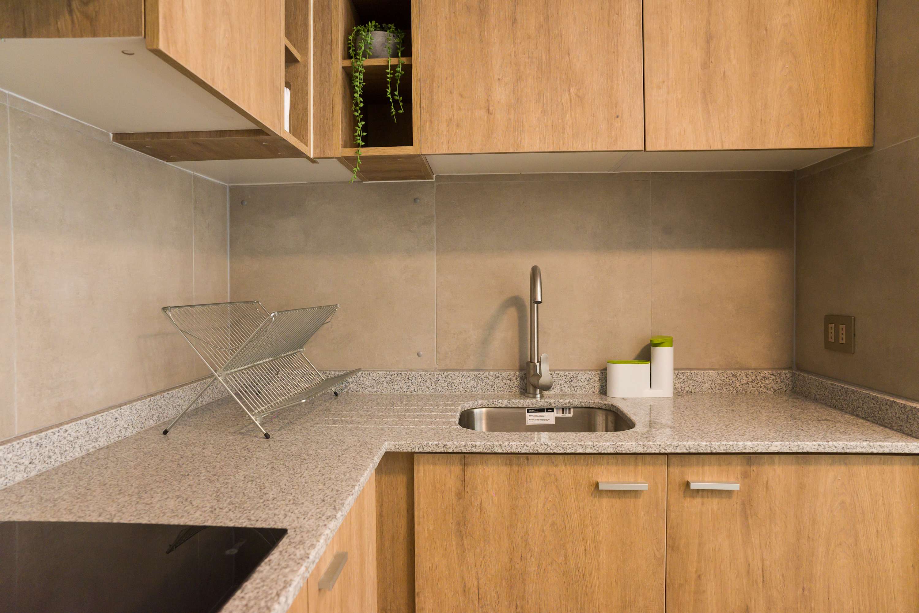 Modern kitchen with sleek wood cabinets and granite countertops, perfect for preparing meals during your stay.