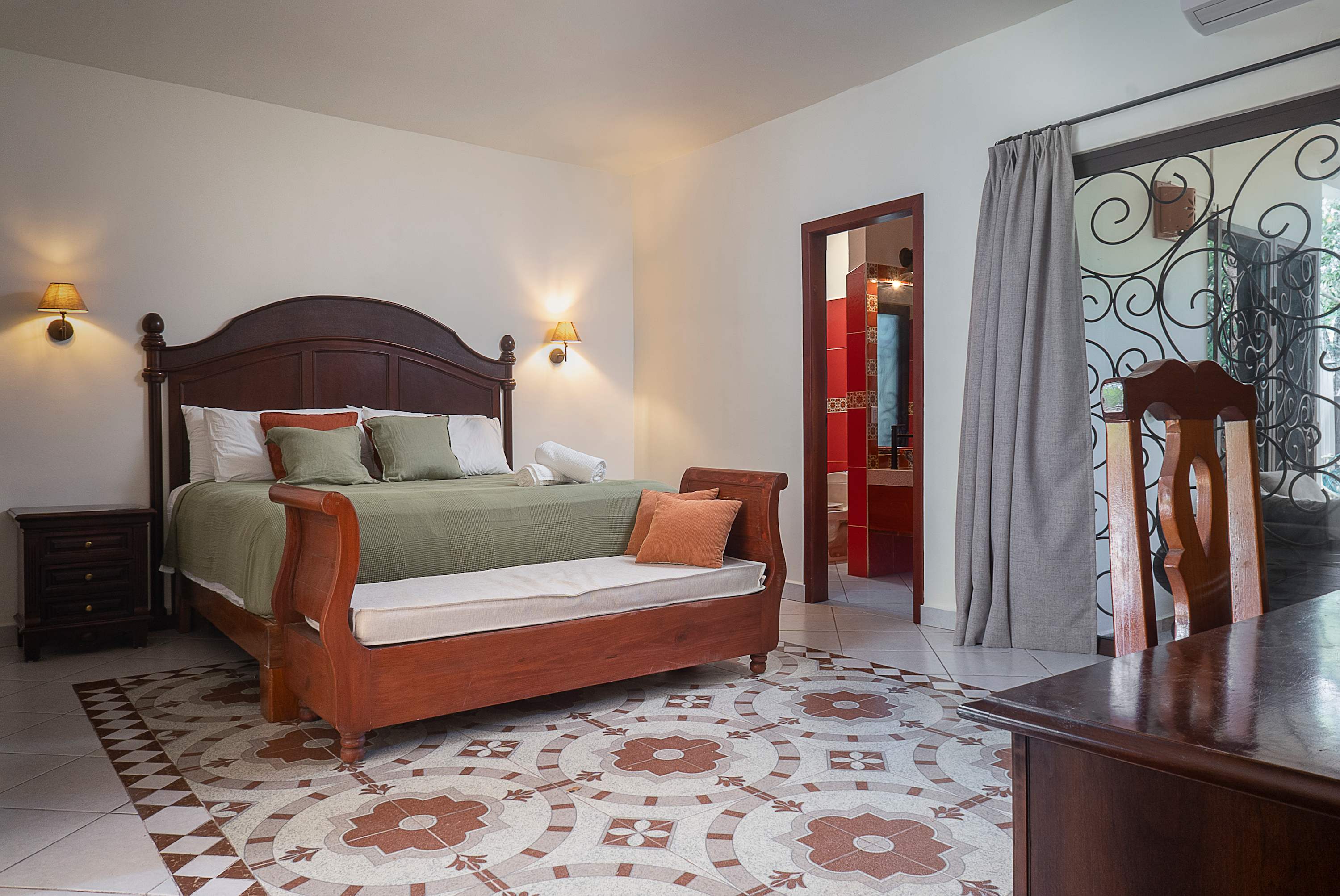 Master bedroom with a king-size bed, featuring warm wood details and an en-suite bathroom
