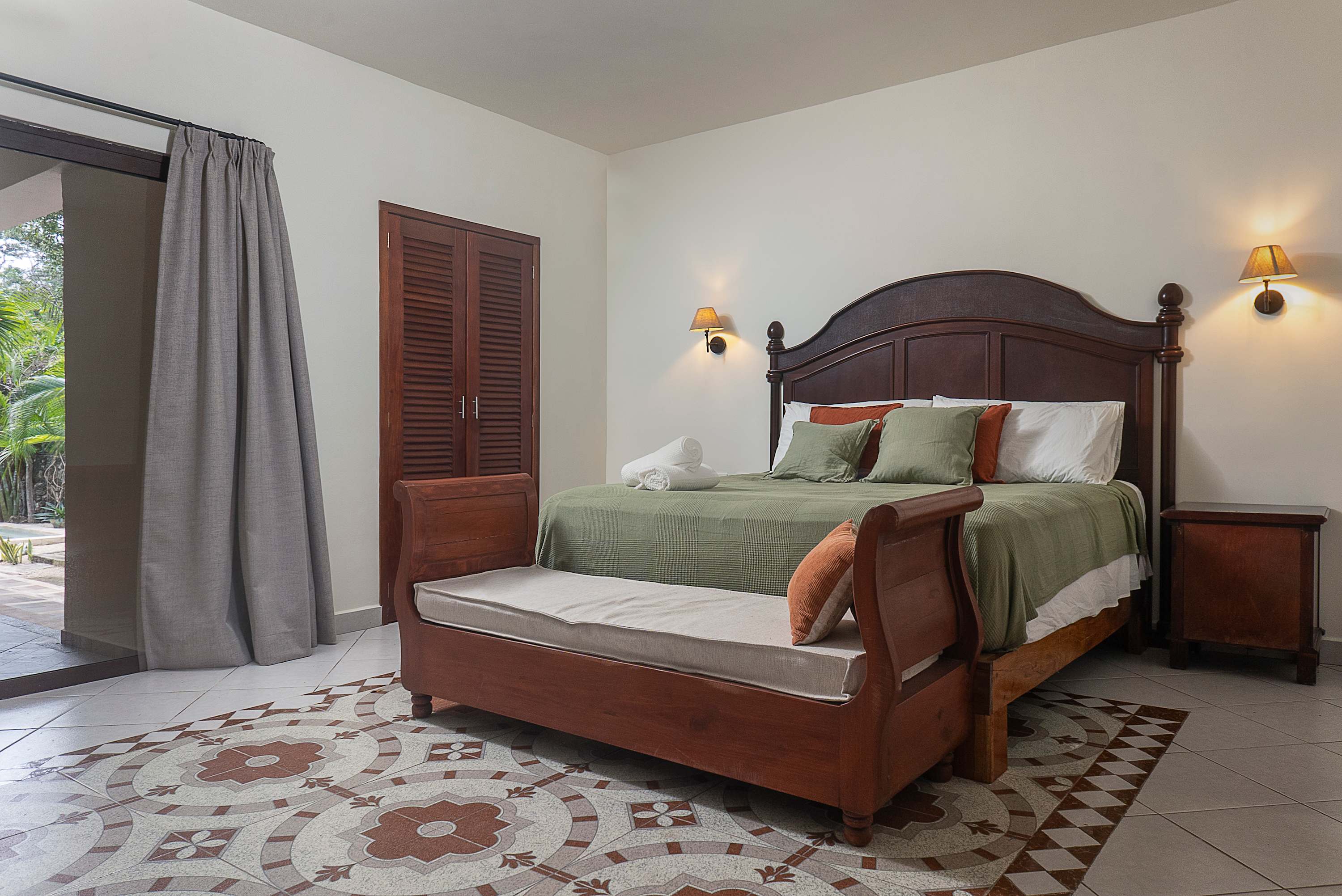 Master bedroom with a king-size bed, featuring warm wood details and an en-suite bathroom