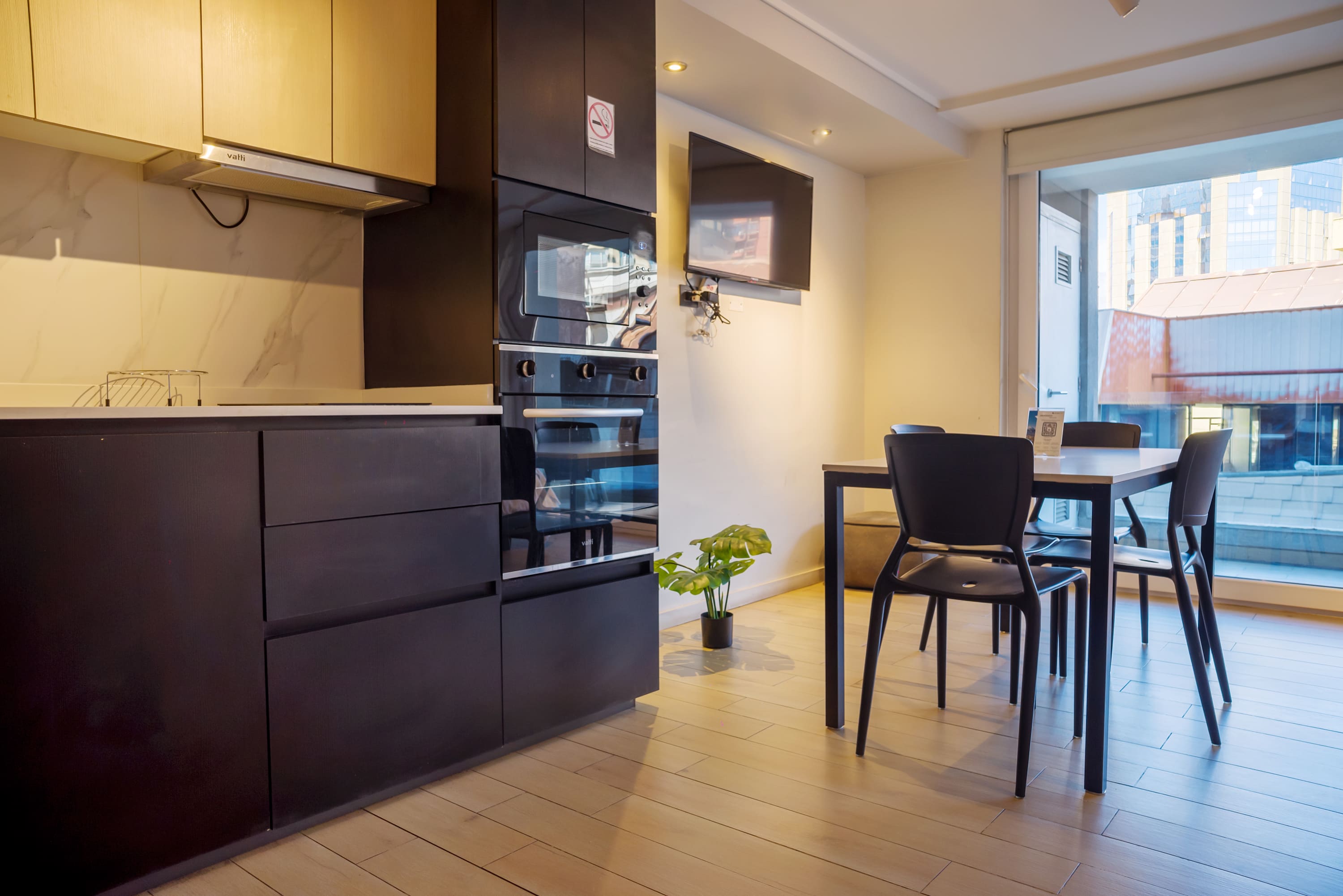 Sleek kitchen and dining area with city views, perfect for enjoying meals in style.