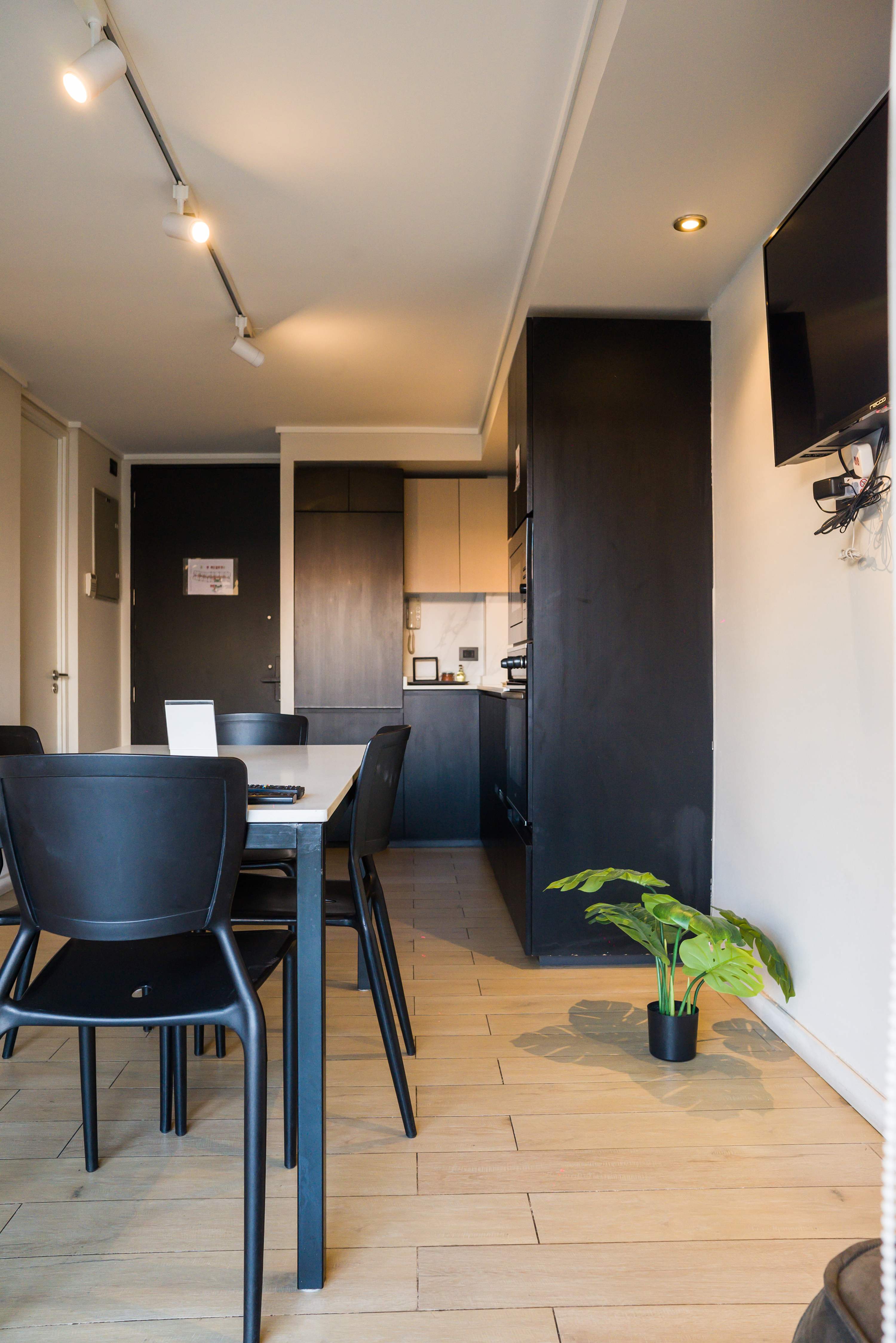 Modern kitchen with sleek black cabinetry and dining area, perfect for cozy meals.