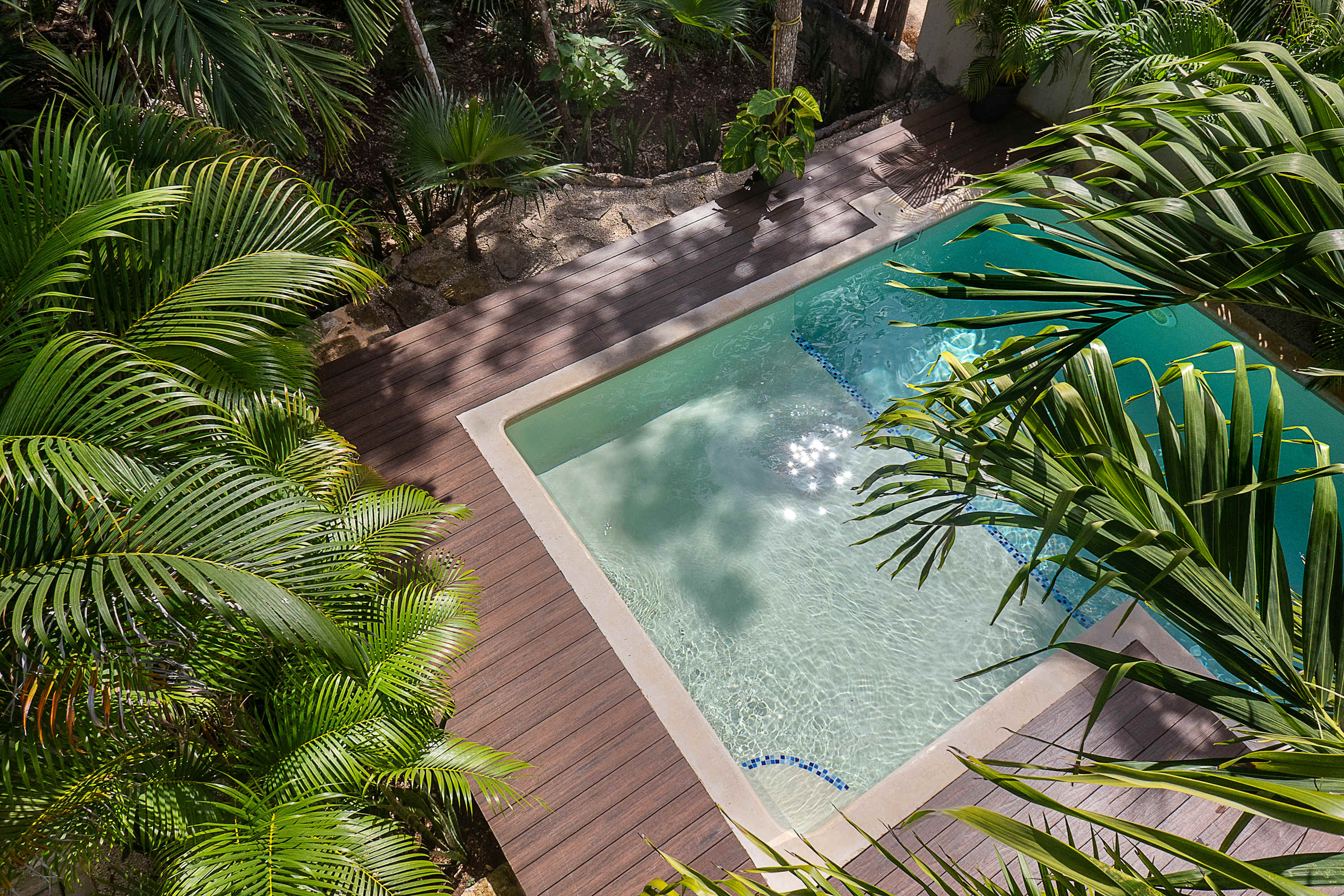 Main floor pool, surrounded by lush greenery. With sun loungers, outdoor dining and BBQ 