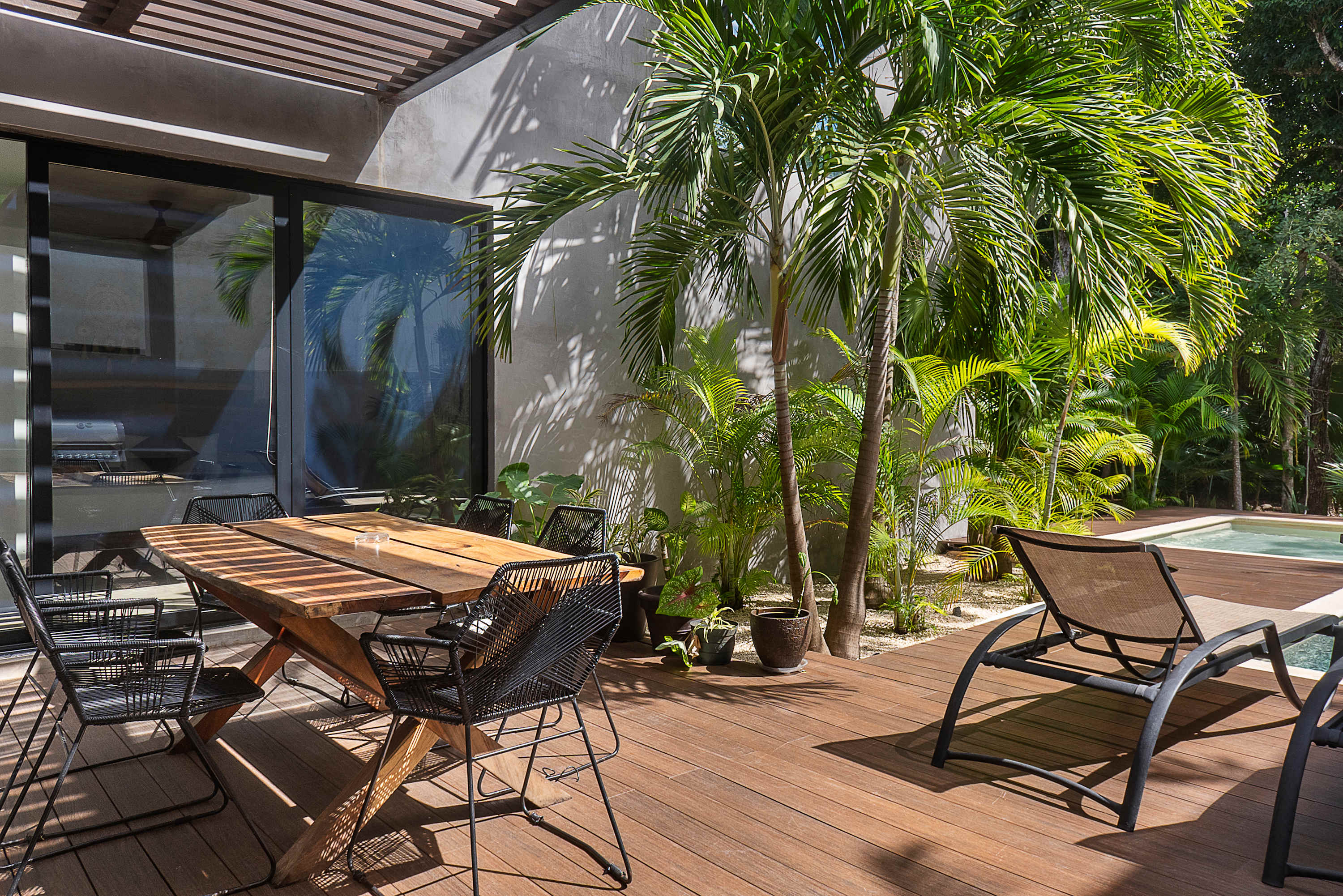 Main floor pool, surrounded by lush greenery. With sun loungers, outdoor dining and BBQ 