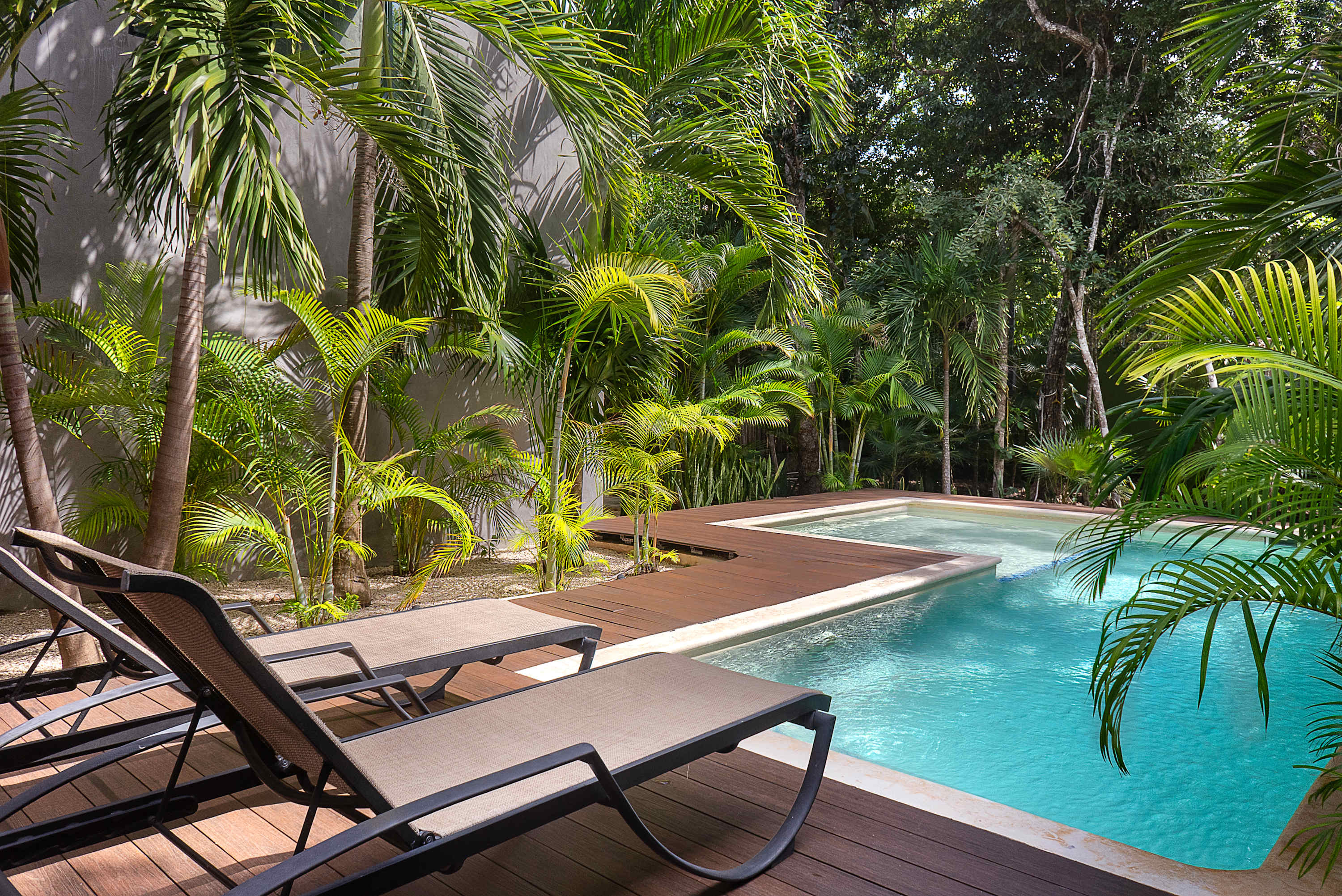 Main floor pool, surrounded by lush greenery. With sun loungers, outdoor dining and BBQ 