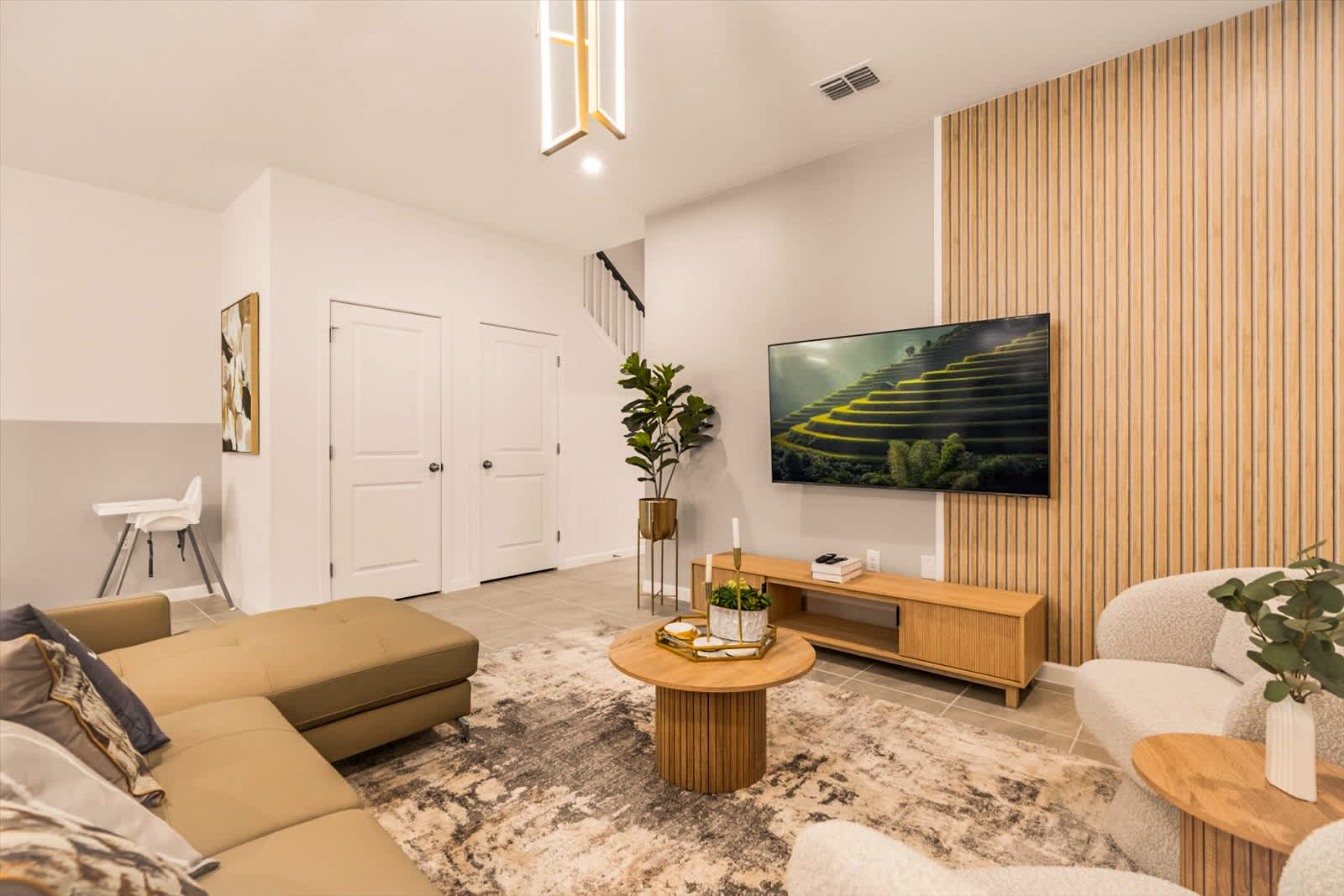 Relax in this stylish living room with modern decor, a cozy sectional, and a large TV for entertainment.