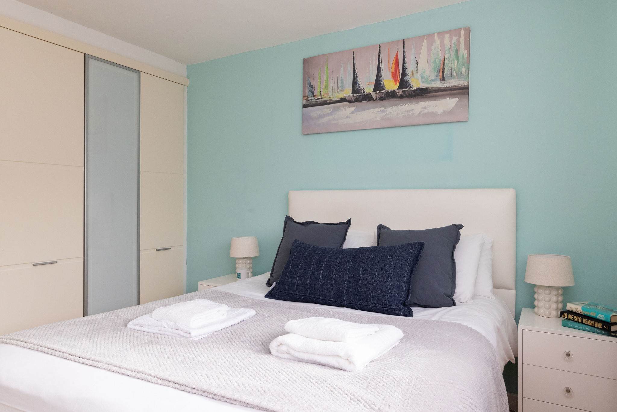 Calming double bedroom with soft coastal décor, fresh linens, and ample storage for a comfortable stay.