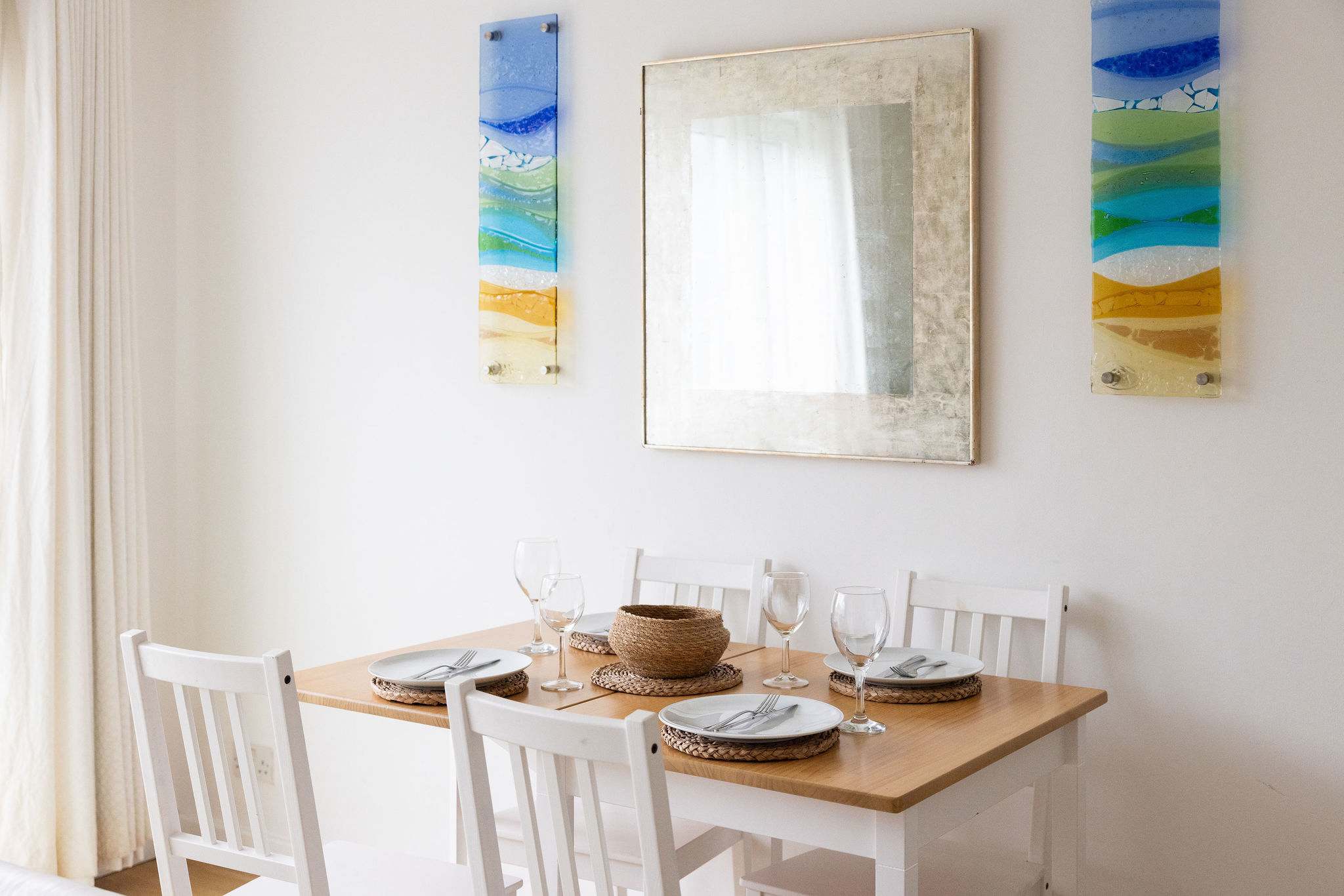Colourful sea-inspired artwork frames the dining area.