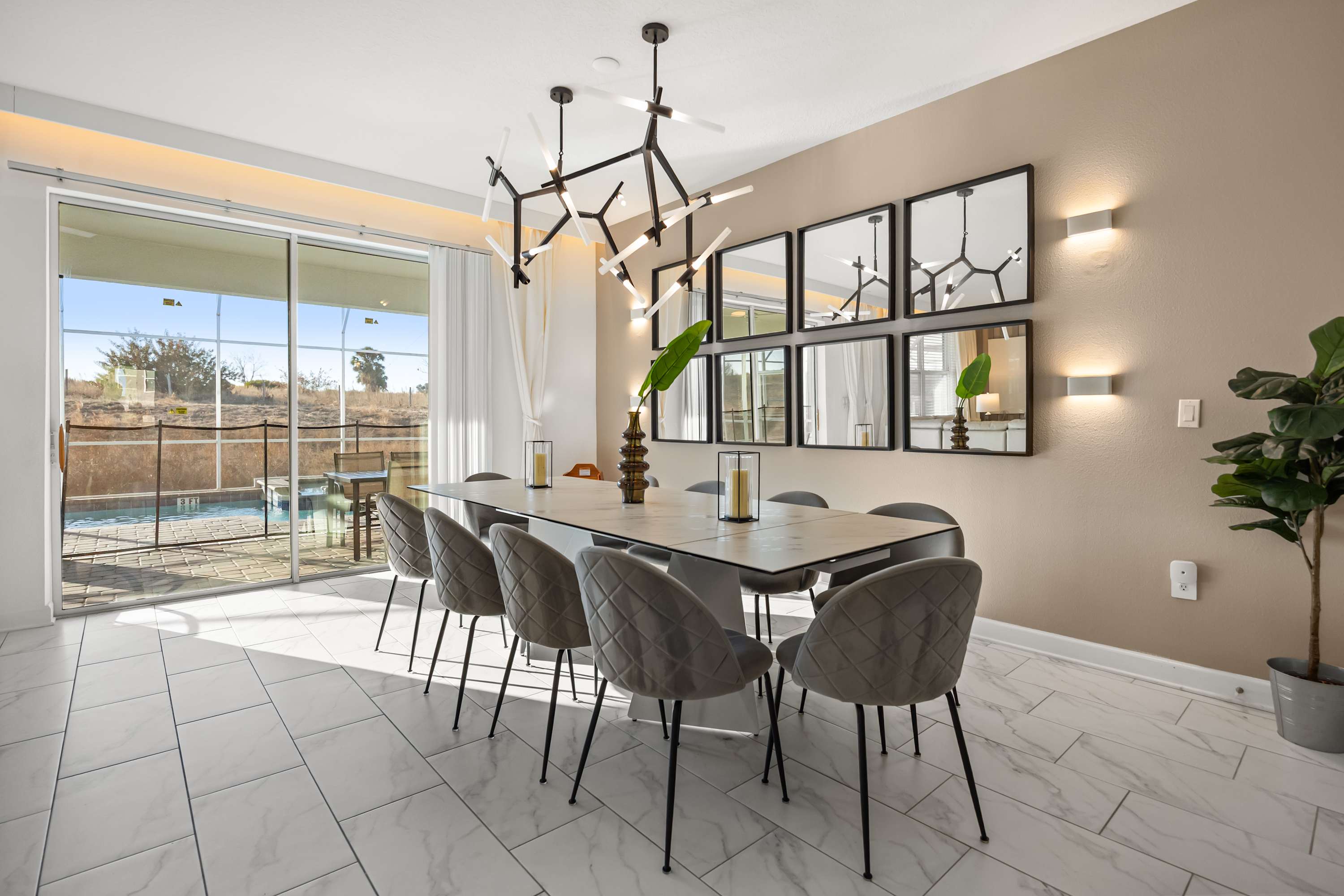 Elegant dining area with seating for eight, modern lighting, and access to a serene outdoor space. Perfect for gatherings.