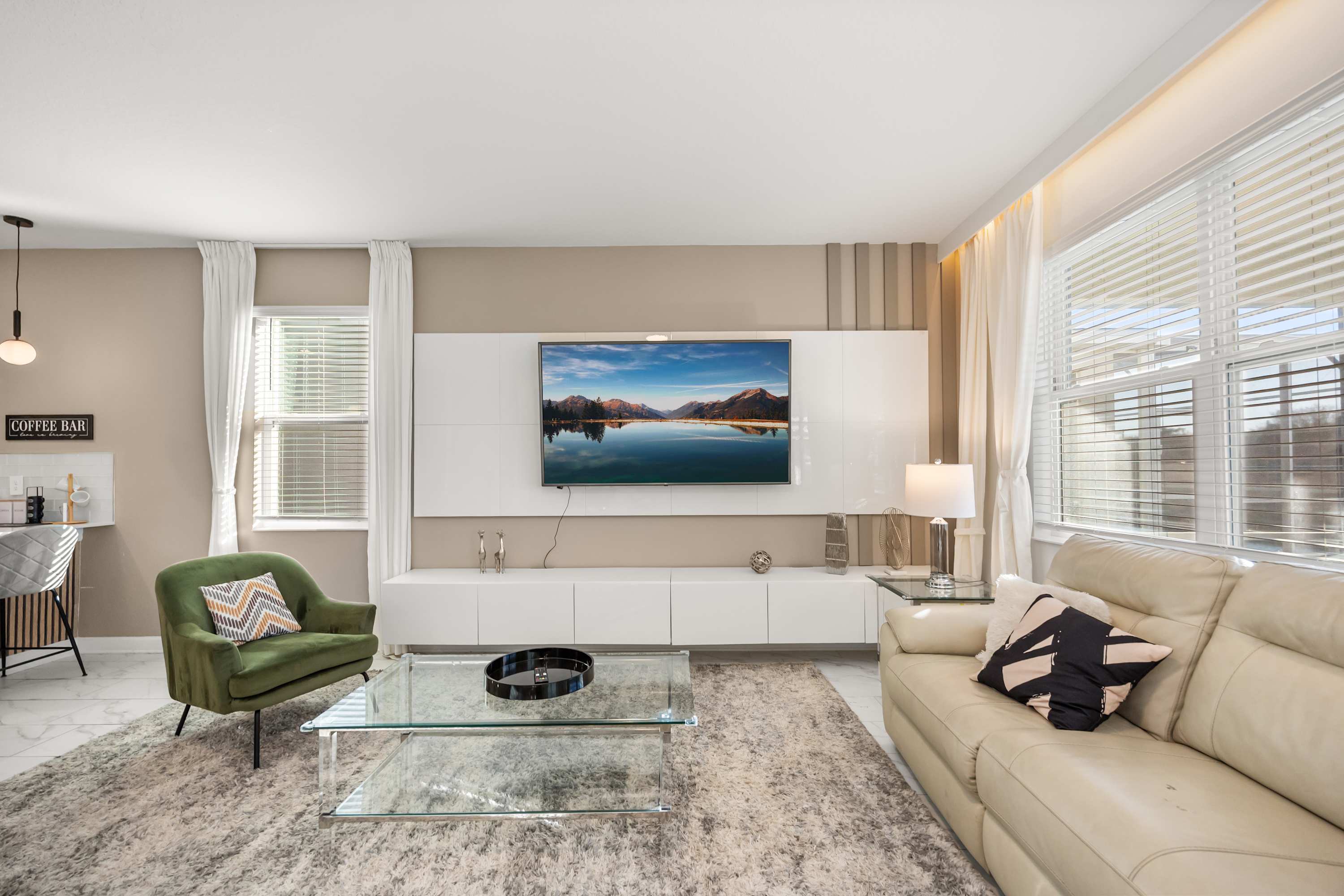 Relax in this stylish living room with a large TV, plush seating, and natural light, perfect for unwinding after a day of exploring.