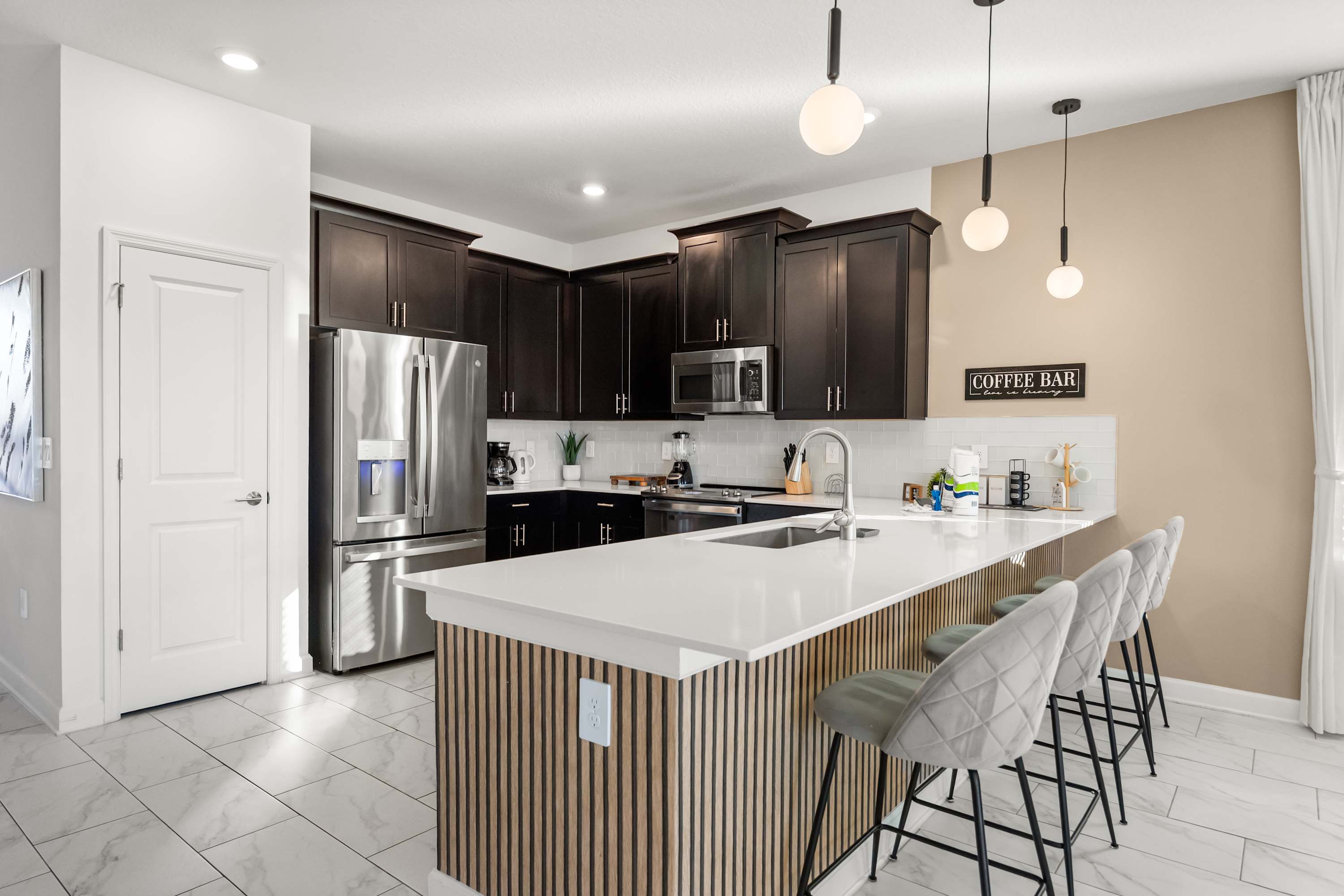 Sleek and modern kitchen with a breakfast bar and stainless steel appliances, perfect for culinary adventures.
