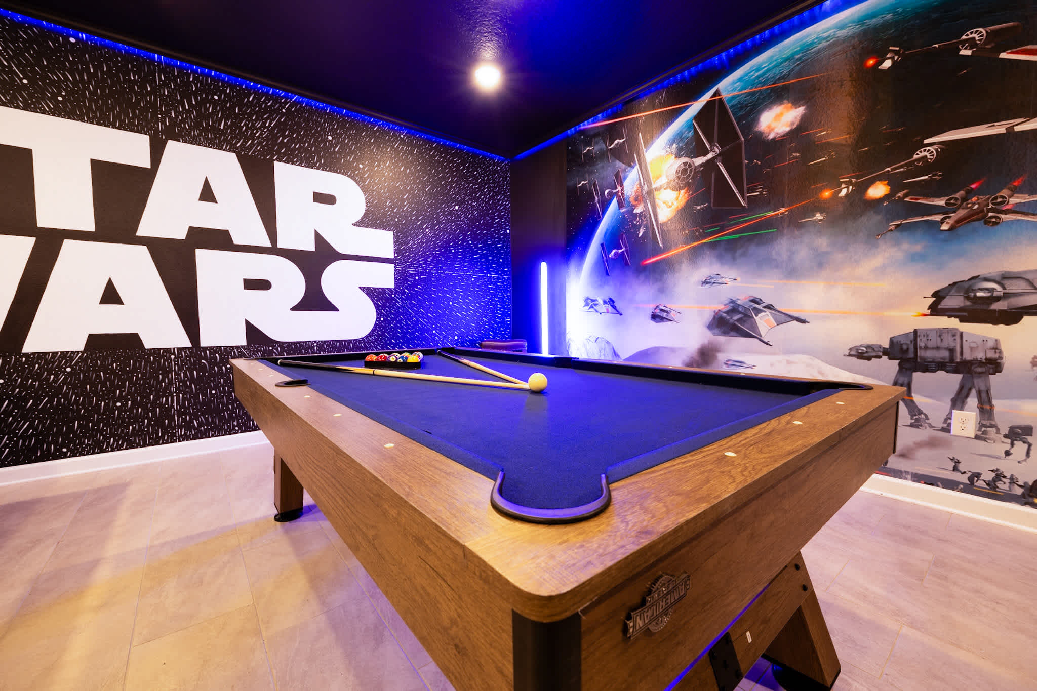 Immerse yourself in a Star Wars-themed game room with a sleek pool table and vibrant murals, perfect for family fun and entertainment.