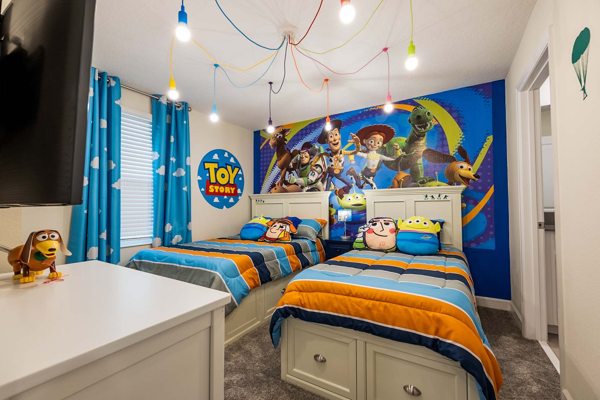 Delight kids with a Toy Story-themed room featuring vibrant decor and cozy twin beds for a fun stay.