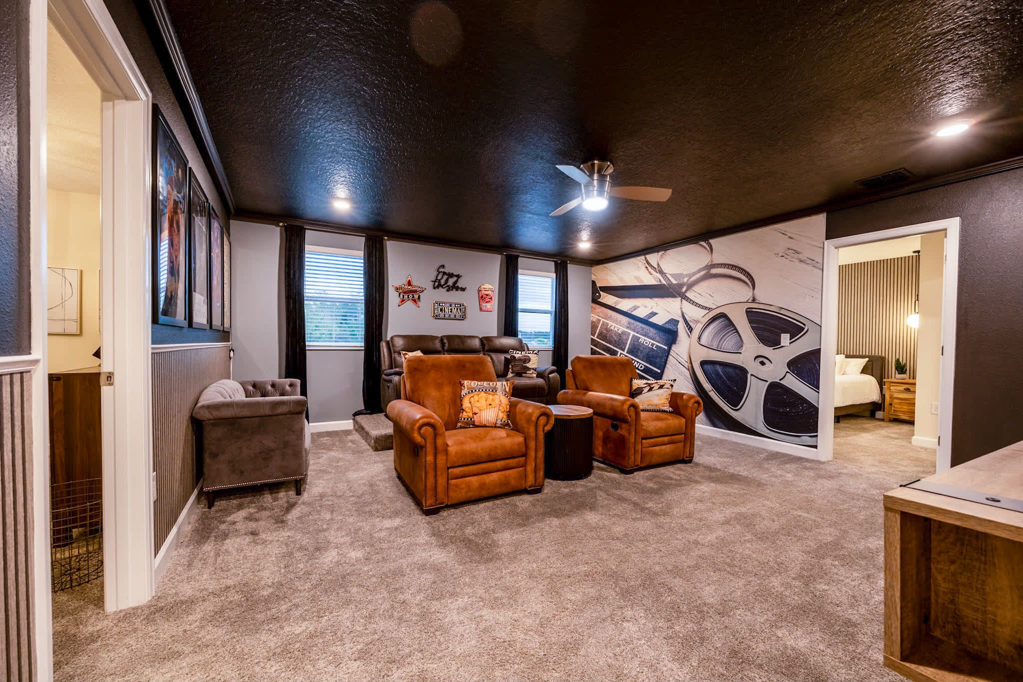 Enjoy movie nights in this cozy, cinema-themed game room with plush seating and film-inspired decor.