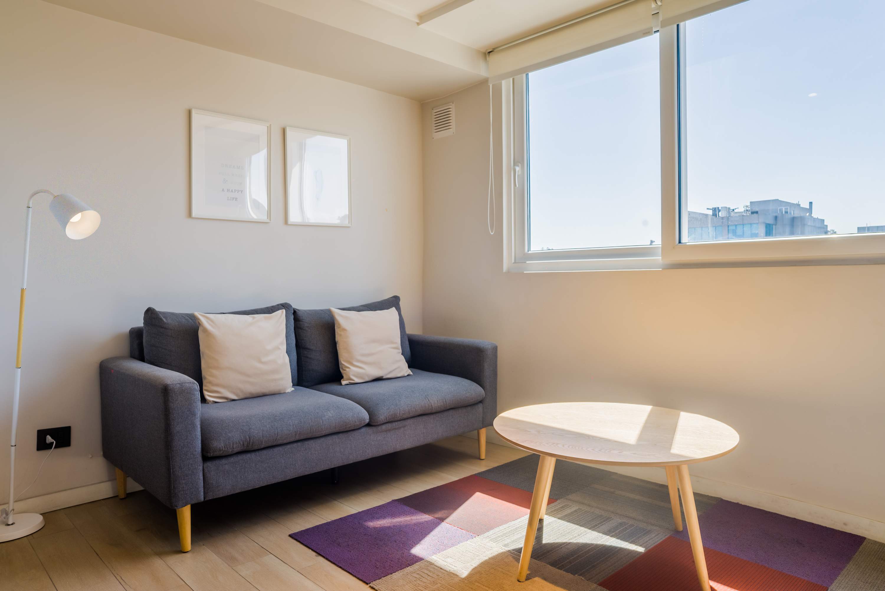 Bright and cozy living space with a comfy sofa and natural light, perfect for relaxation.