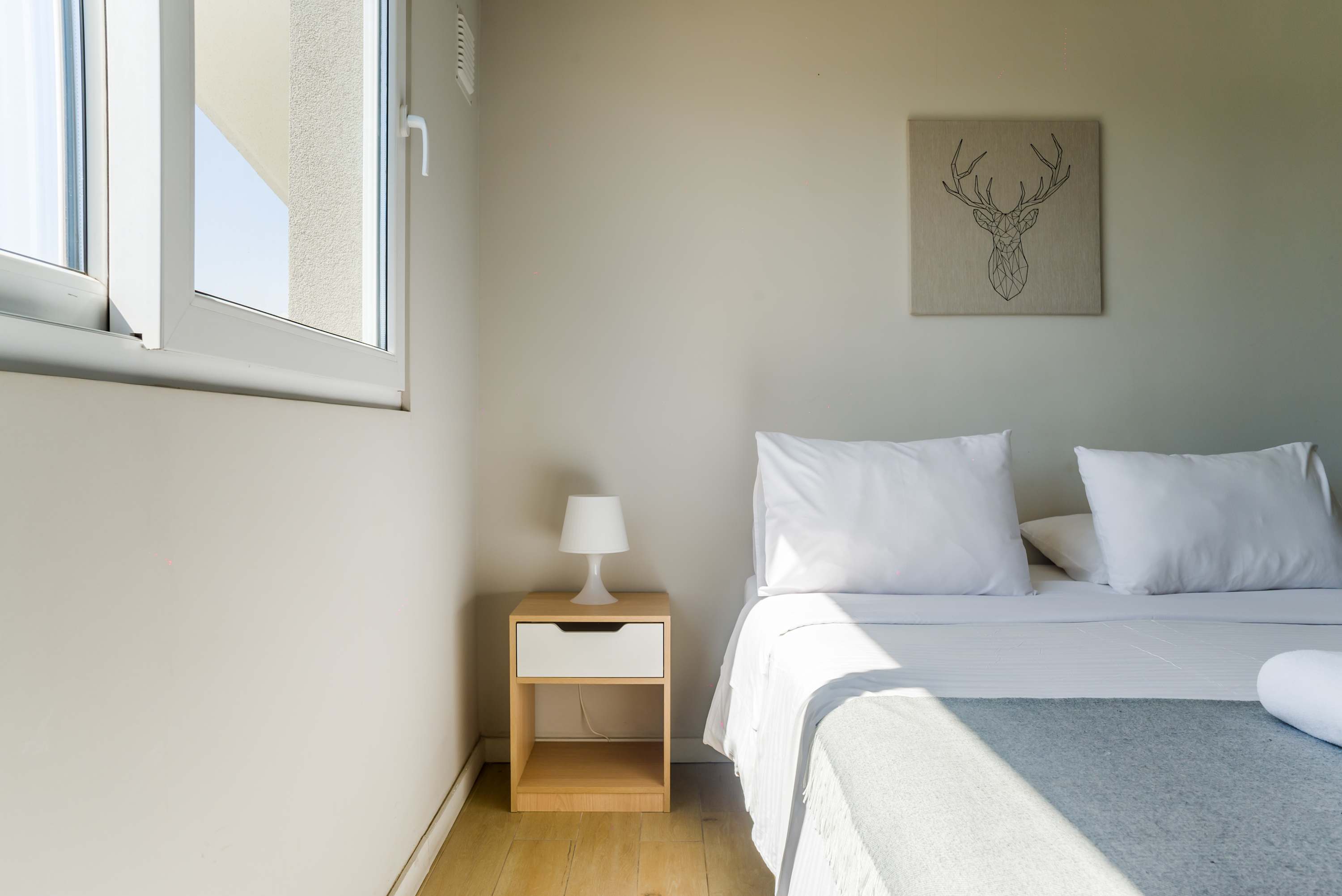 Bright and cozy bedroom with natural light and minimalist decor, perfect for a relaxing stay.