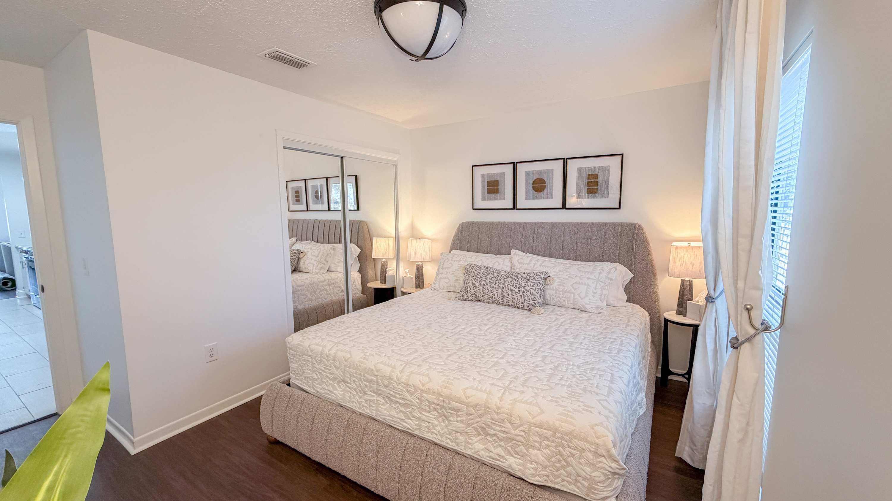 300 W 23rd Pl – Cozy bedroom with a king-size bed, framed artwork, and natural light from windows.