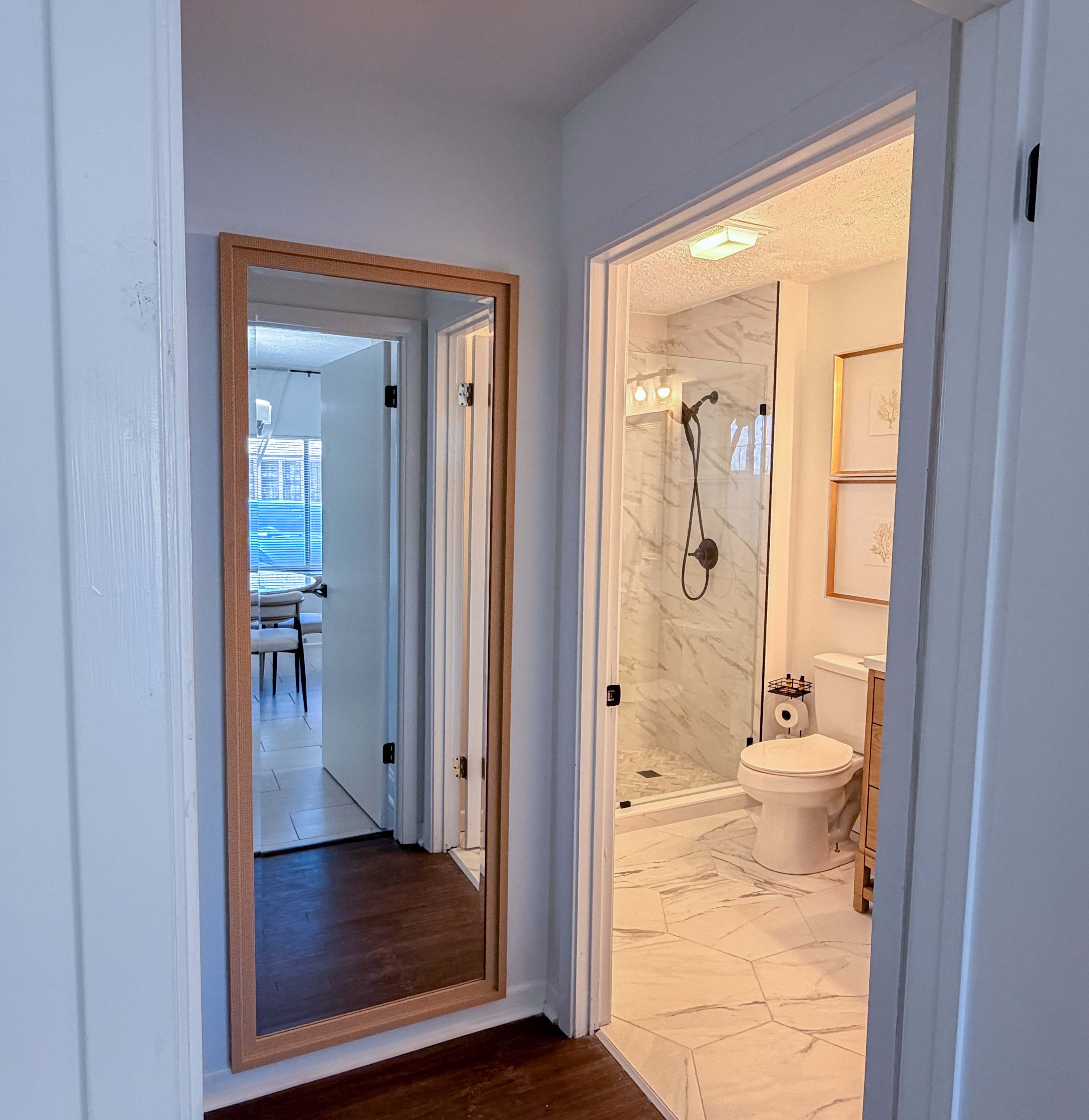 300 W 23rd Pl – View of a bathroom with shower, toilet, and a mirror in a hallway.