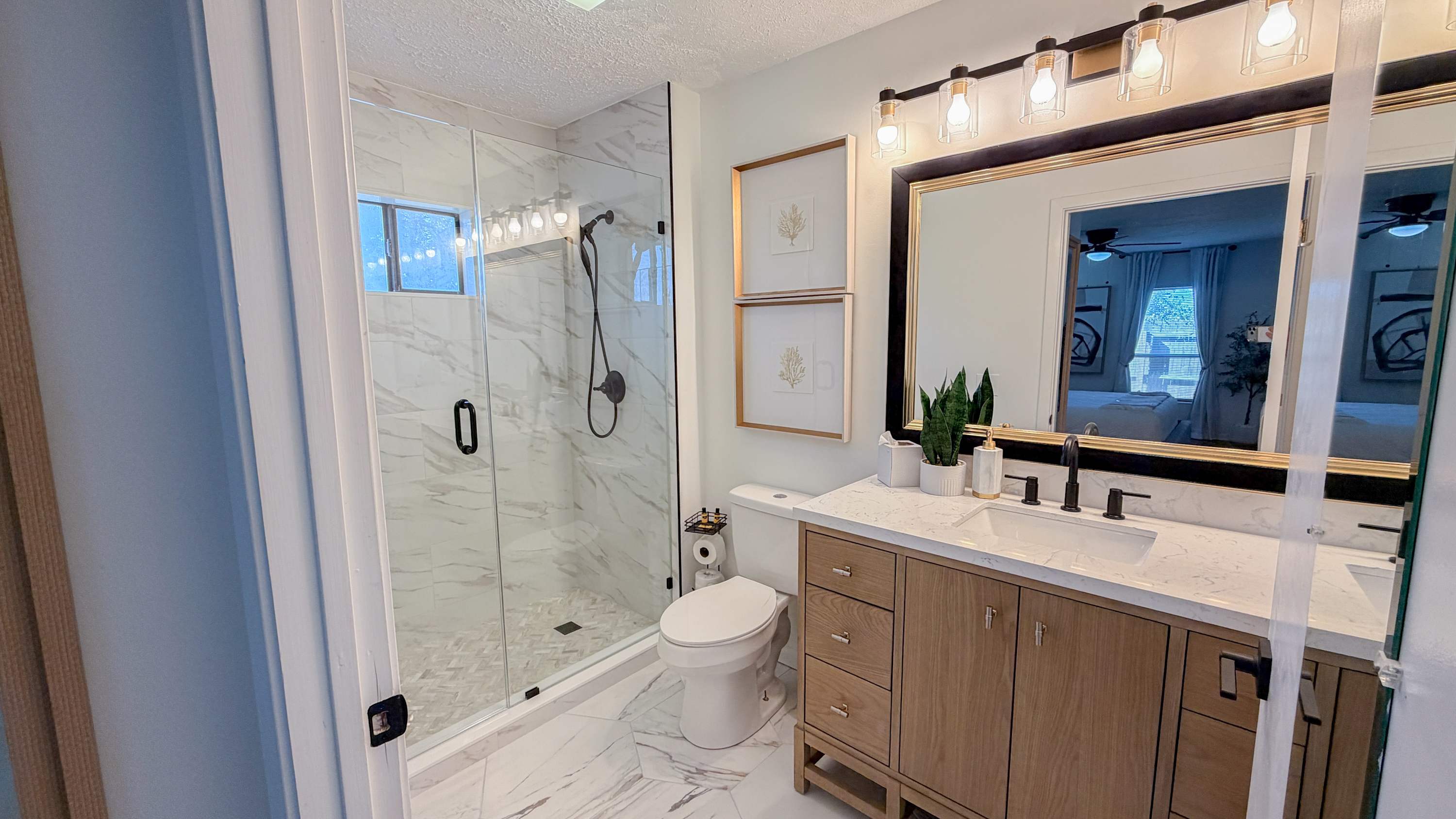 300 W 23rd Pl – Bathroom featuring a glass shower, vanity with dual sinks, and modern decor.