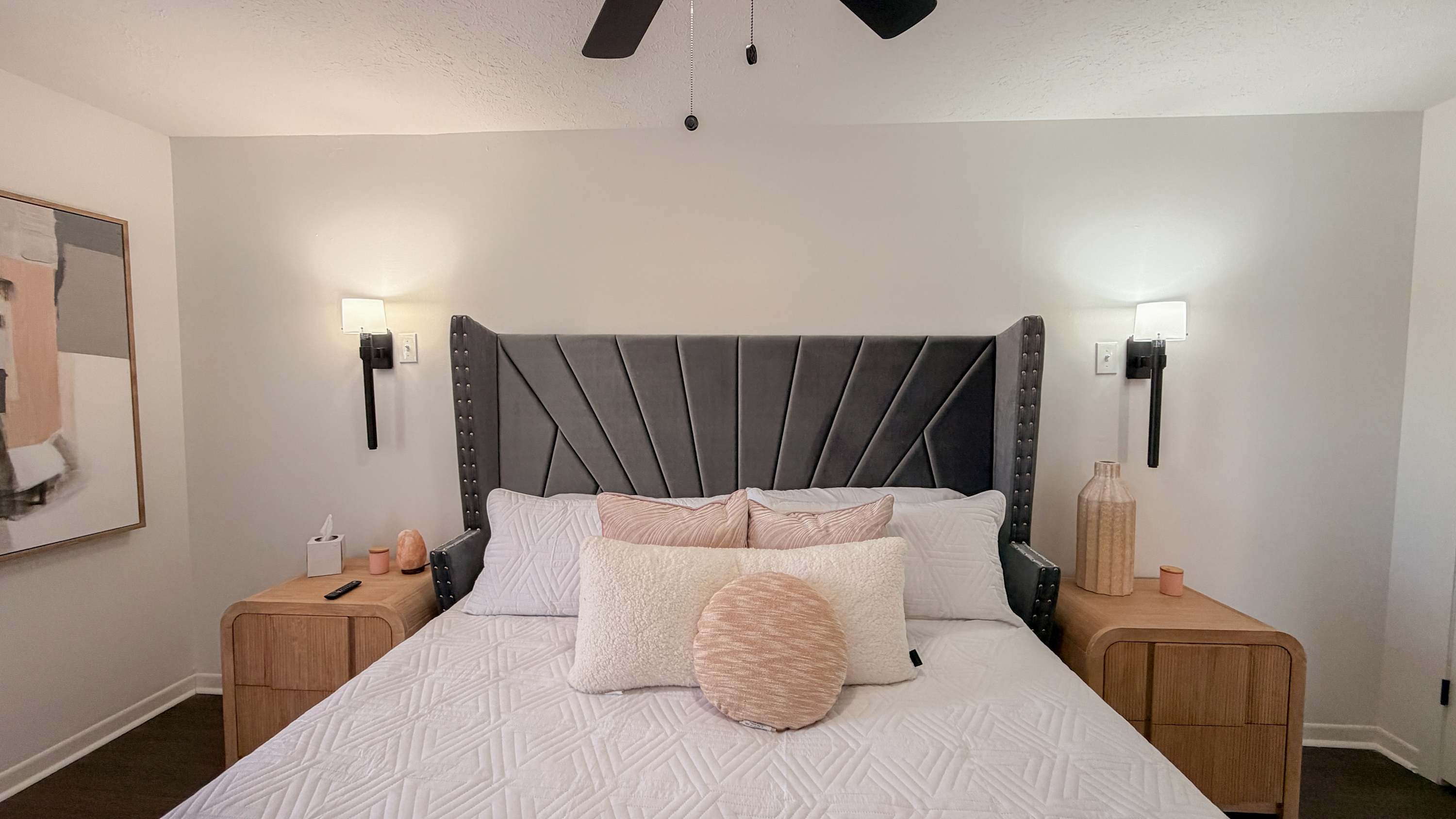 300 W 23rd Pl – Modern bedroom with a gray upholstered bed, two side tables, and abstract wall art.
