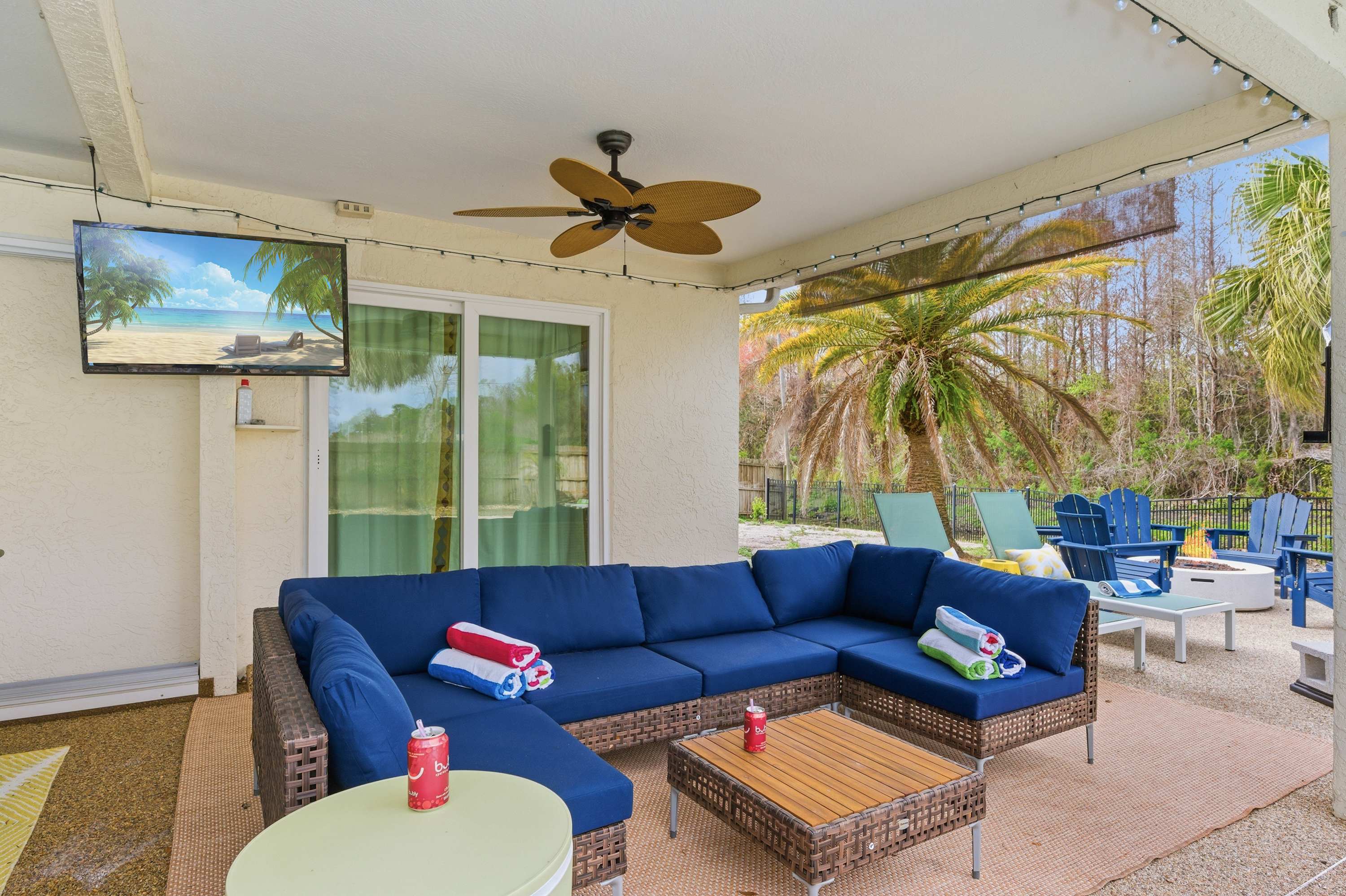Relaxed living area w/ a large sectional, TV & ceiling fan.