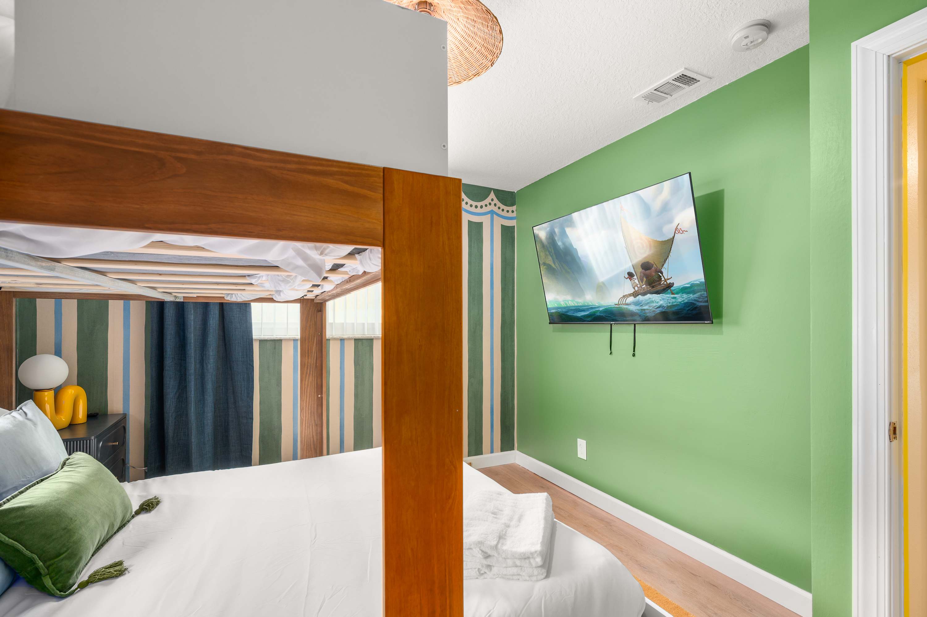 Cozy bedroom w/ TV, wood-framed mirror & warm, layered decor.