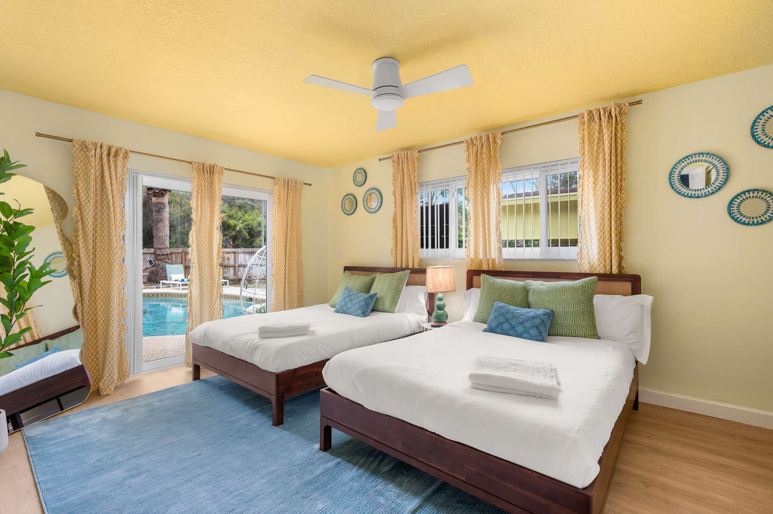 Cozy bedroom w/ two beds, cheerful decor & natural light.